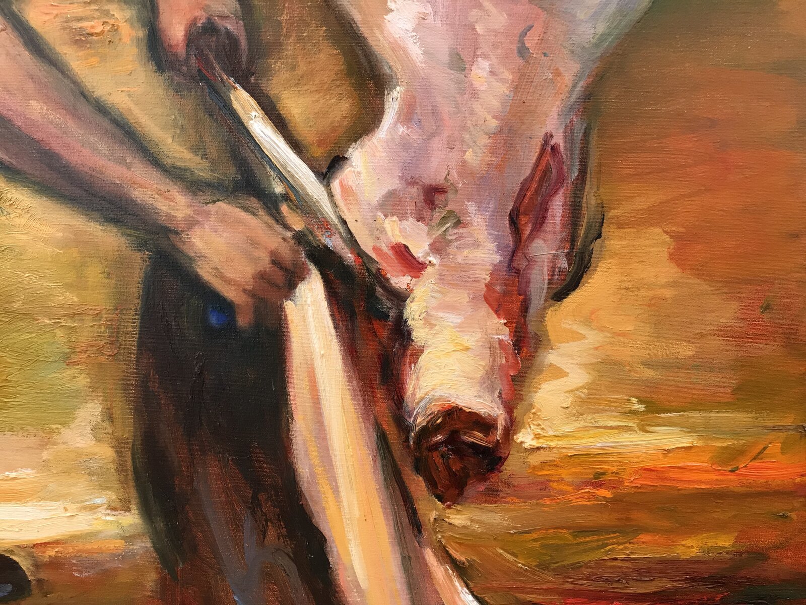 A butcher in a white cap works at a hanging carcass in a dimly lit, warm-toned workshop.