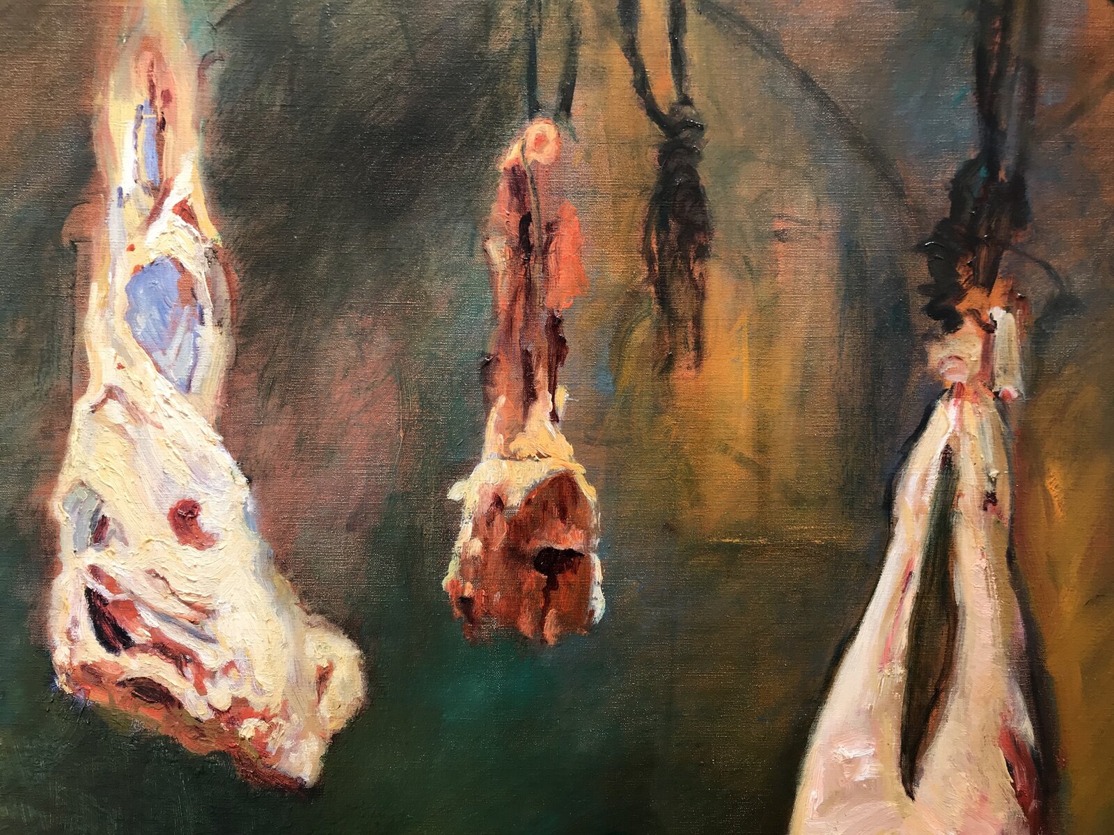 A butcher in a white cap works at a hanging carcass in a dimly lit, warm-toned workshop.