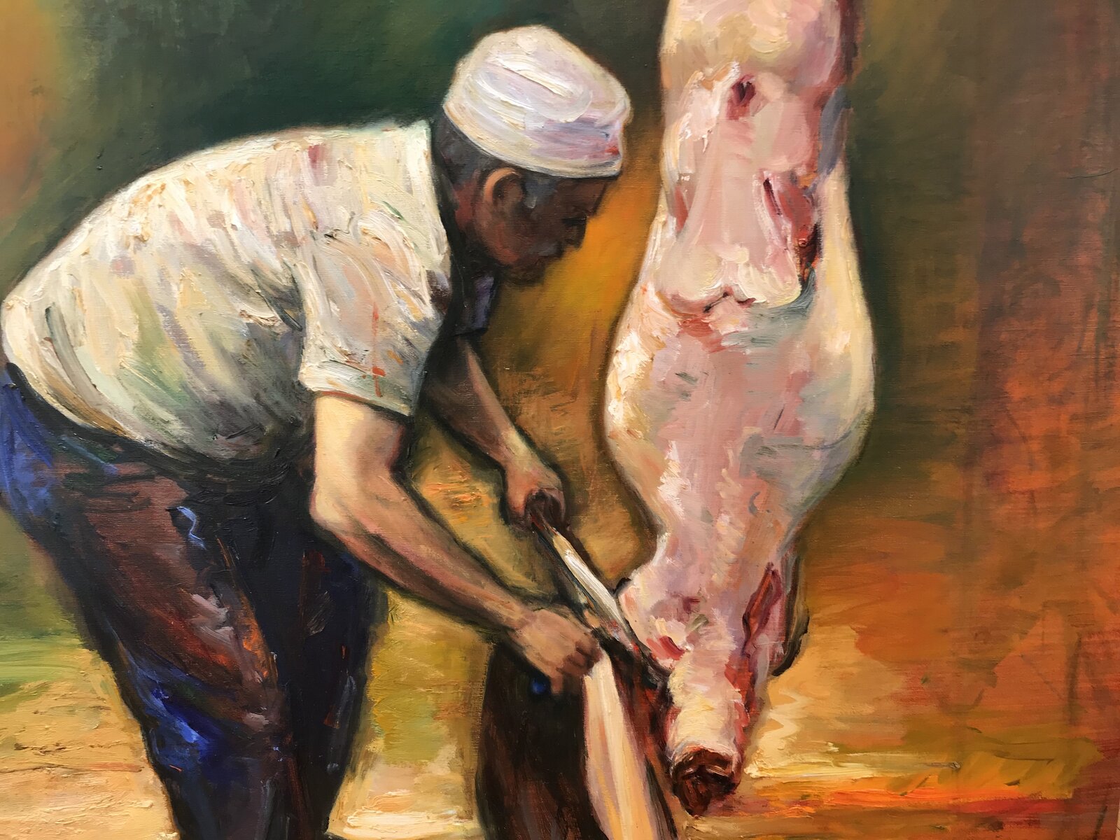 A butcher in a white cap works at a hanging carcass in a dimly lit, warm-toned workshop.