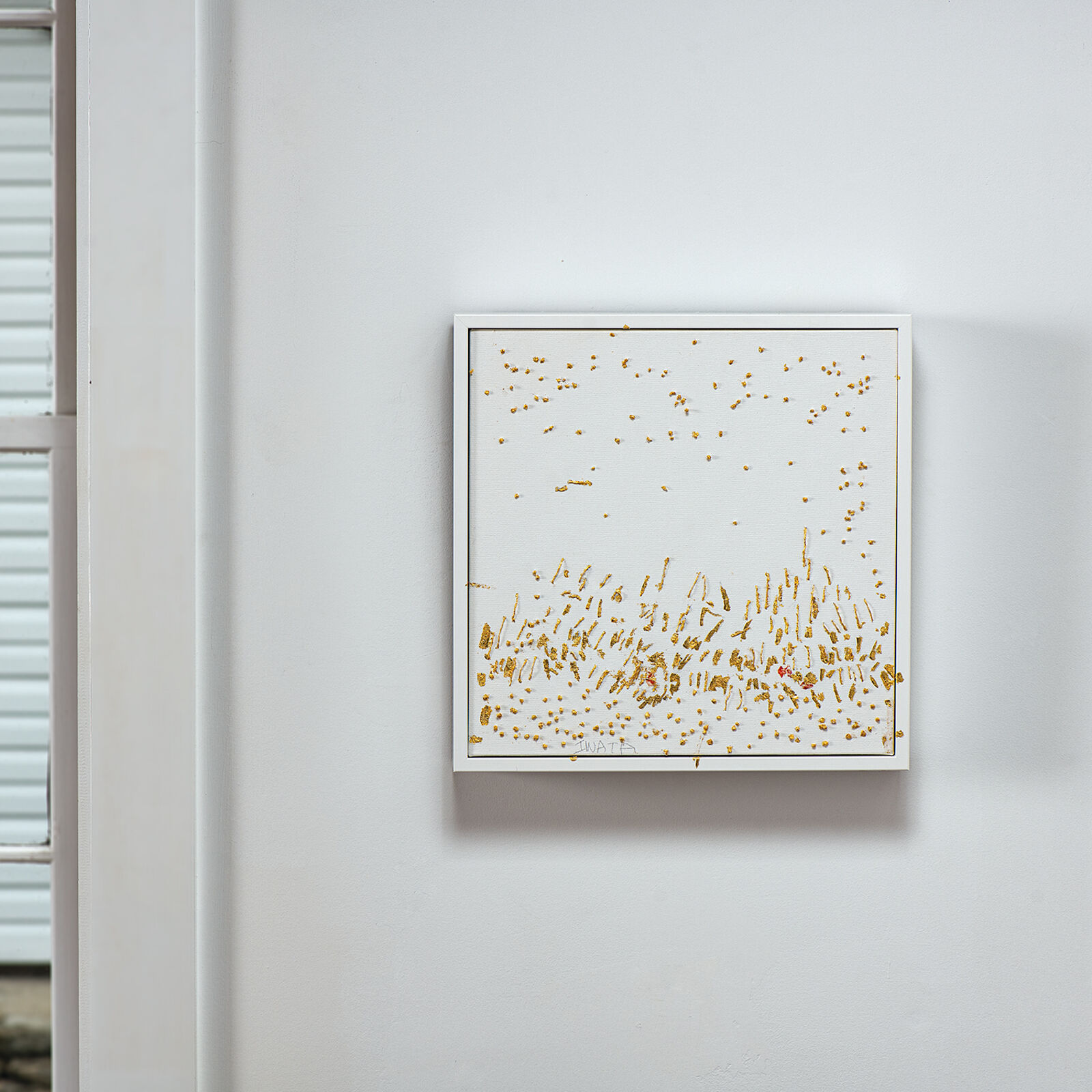 A textured canvas artwork featuring scattered gold leaf fragments and a dense cluster of vertical strokes at the bottom.