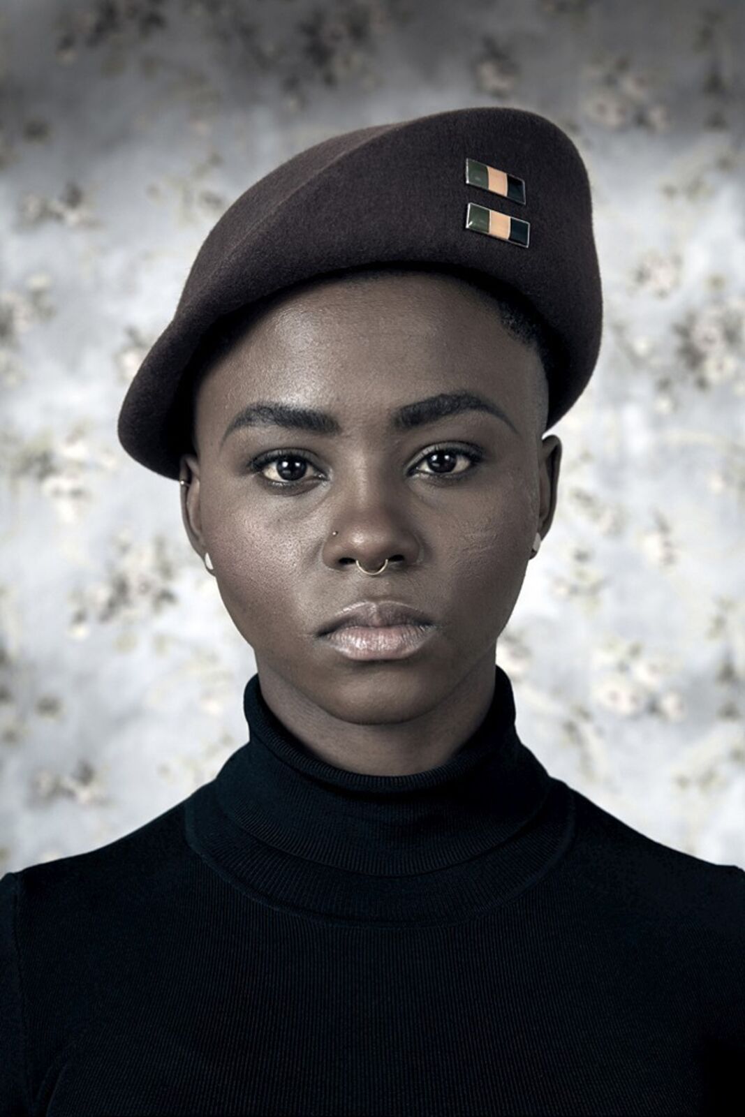 A woman wearing a brown hat and a black turtle neck sweater.