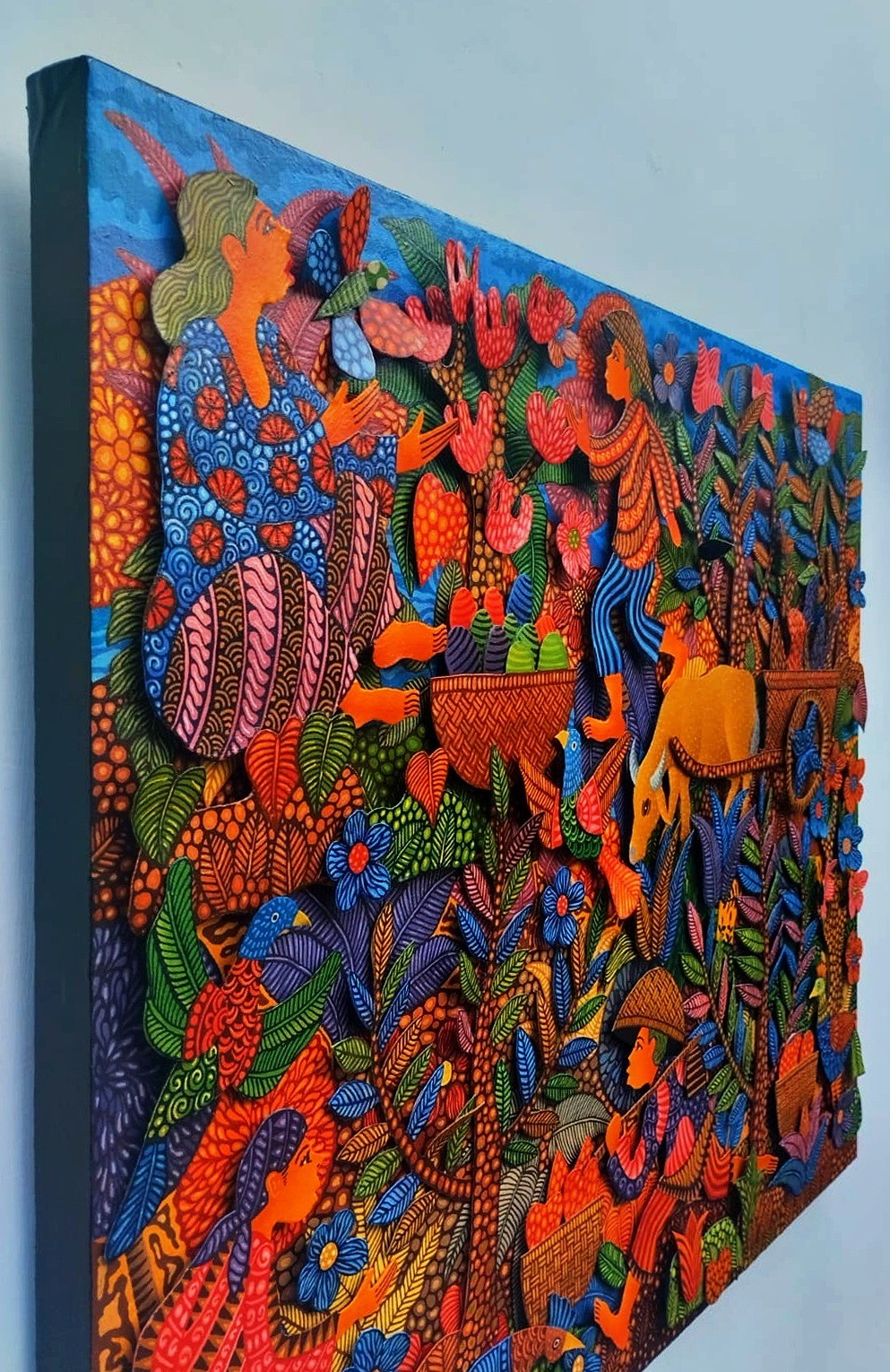 A vibrant, textured tapestry depicting a lush, stylized forest scene filled with figures and animals.