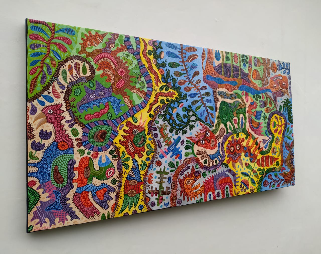 A colorful painting on a white wall in a room.