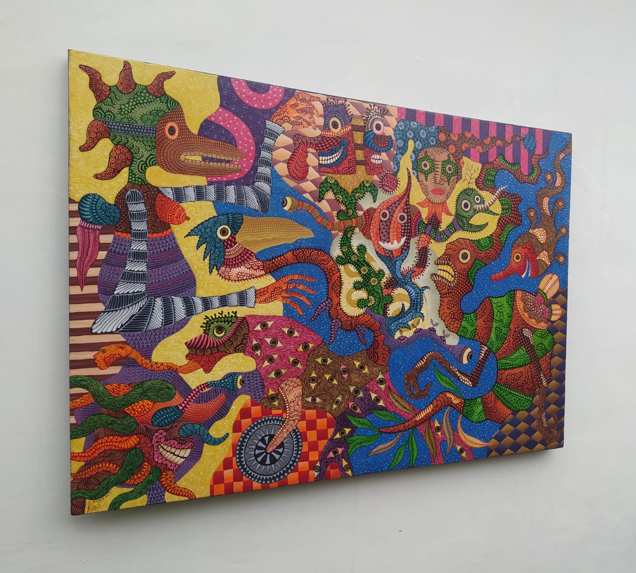 A colorful painting on a white wall in a room.