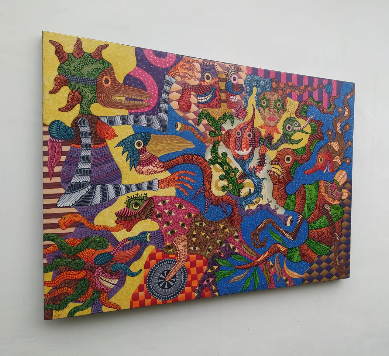 A colorful painting on a white wall in a room.