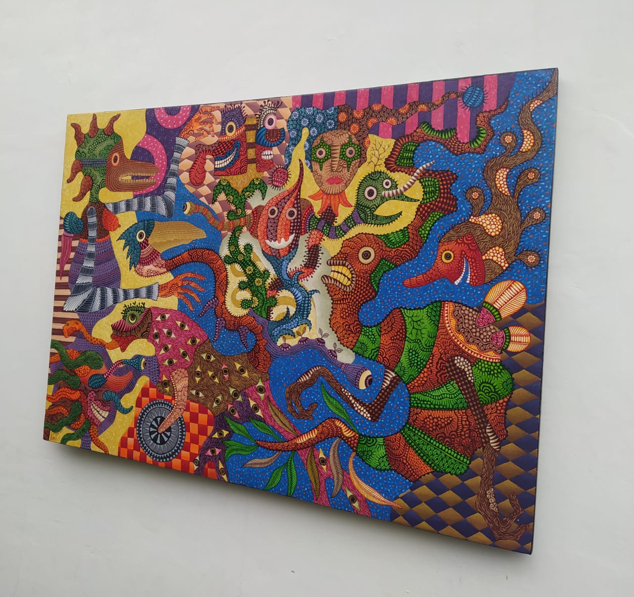 A colorful painting on a white wall in a room.