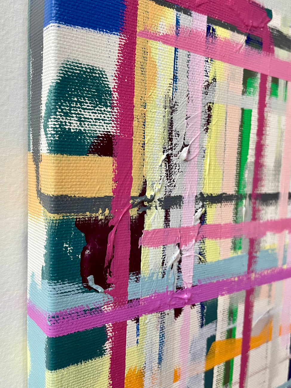 A painting with pink, blue, yellow, and green squares on a white background.
