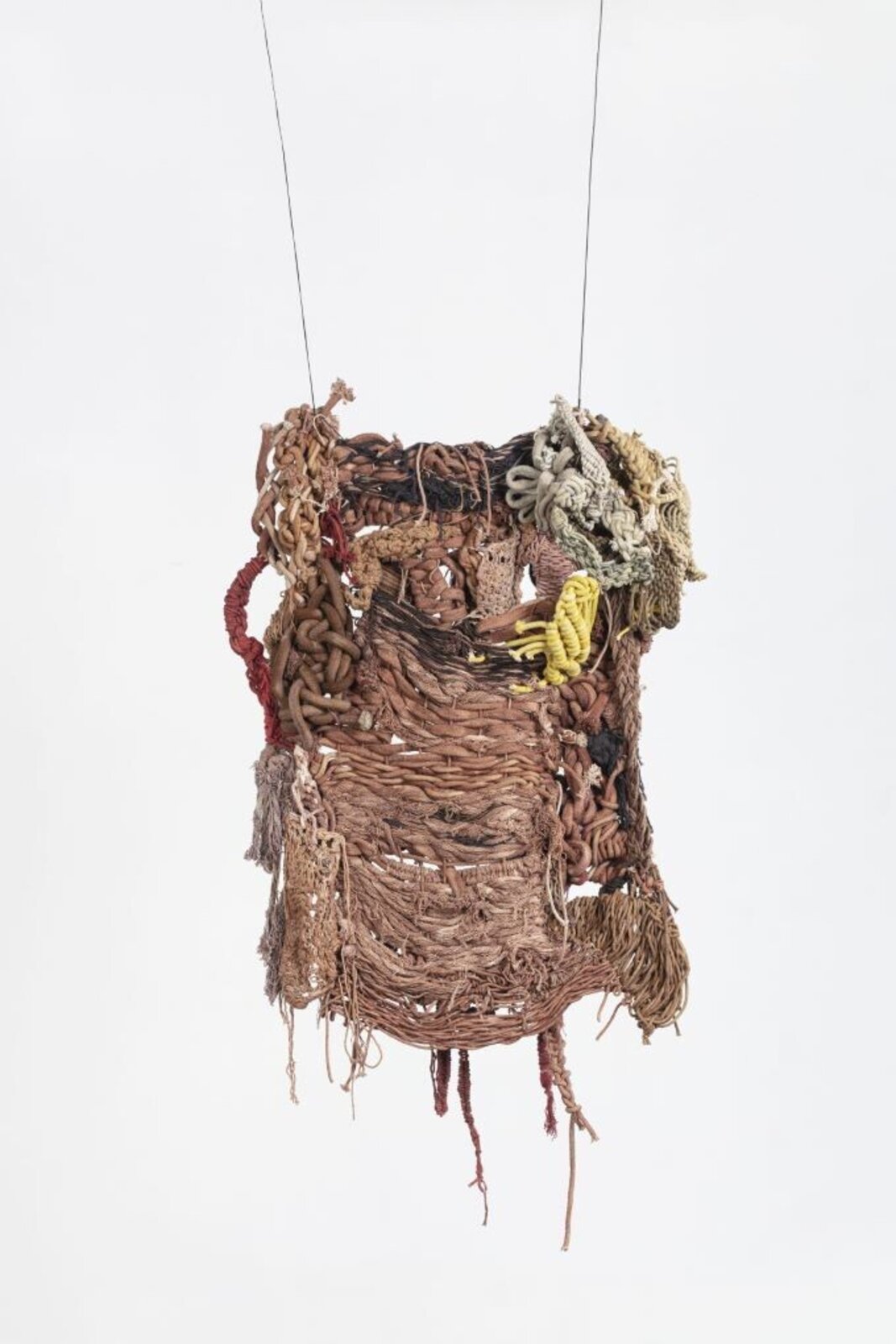 A hanging textile sculpture made of woven fibers and knots.
