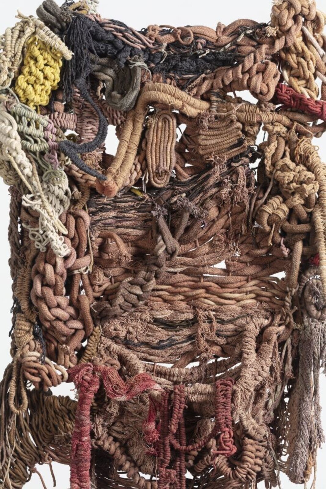 A hanging textile sculpture made of woven fibers and knots.