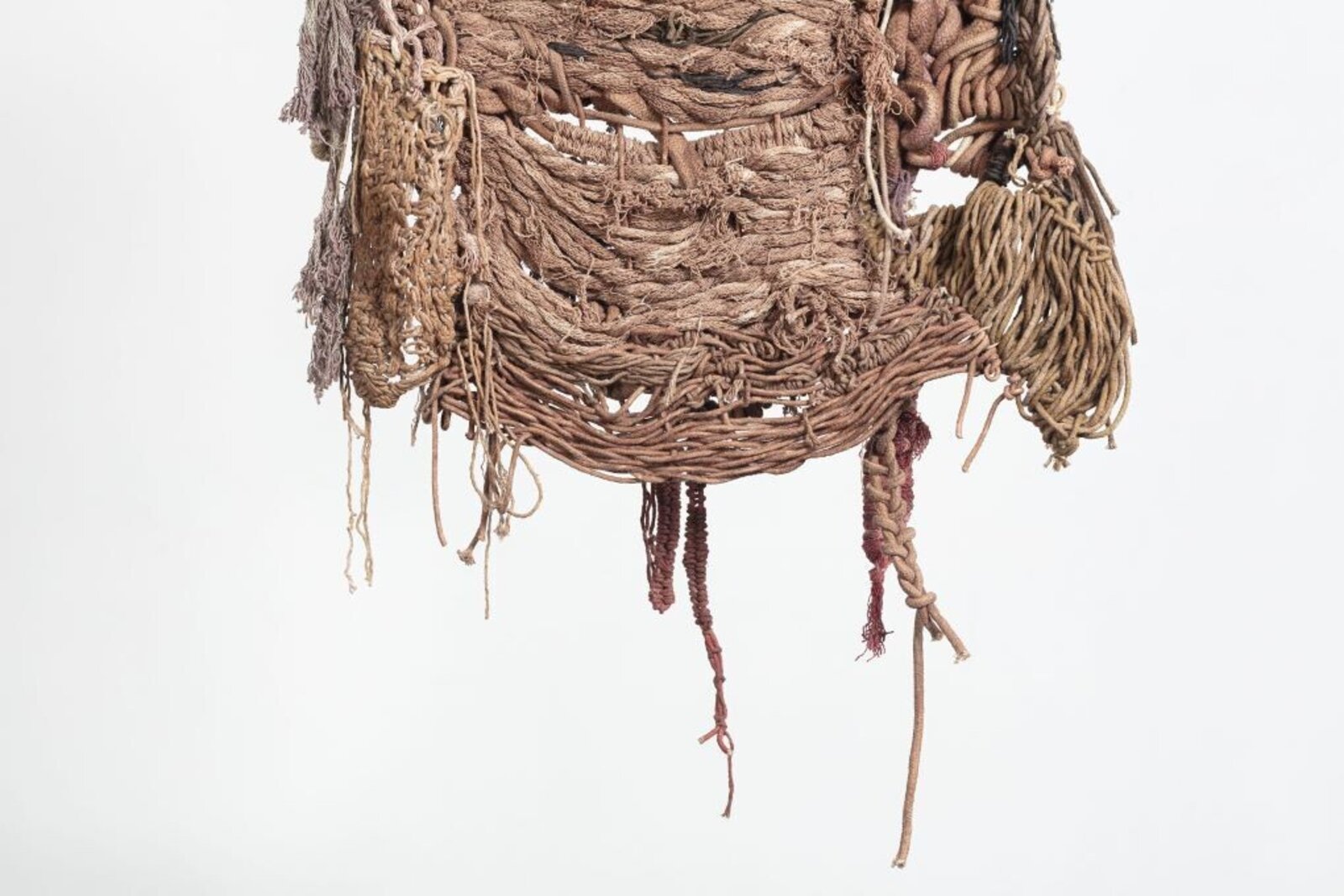 A hanging textile sculpture made of woven fibers and knots.