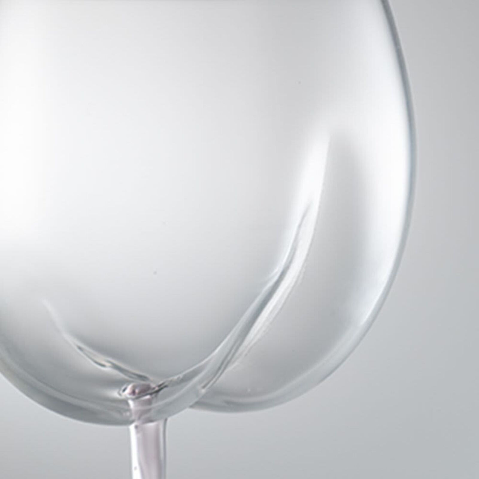 A pair of wine glasses sitting next to each other.