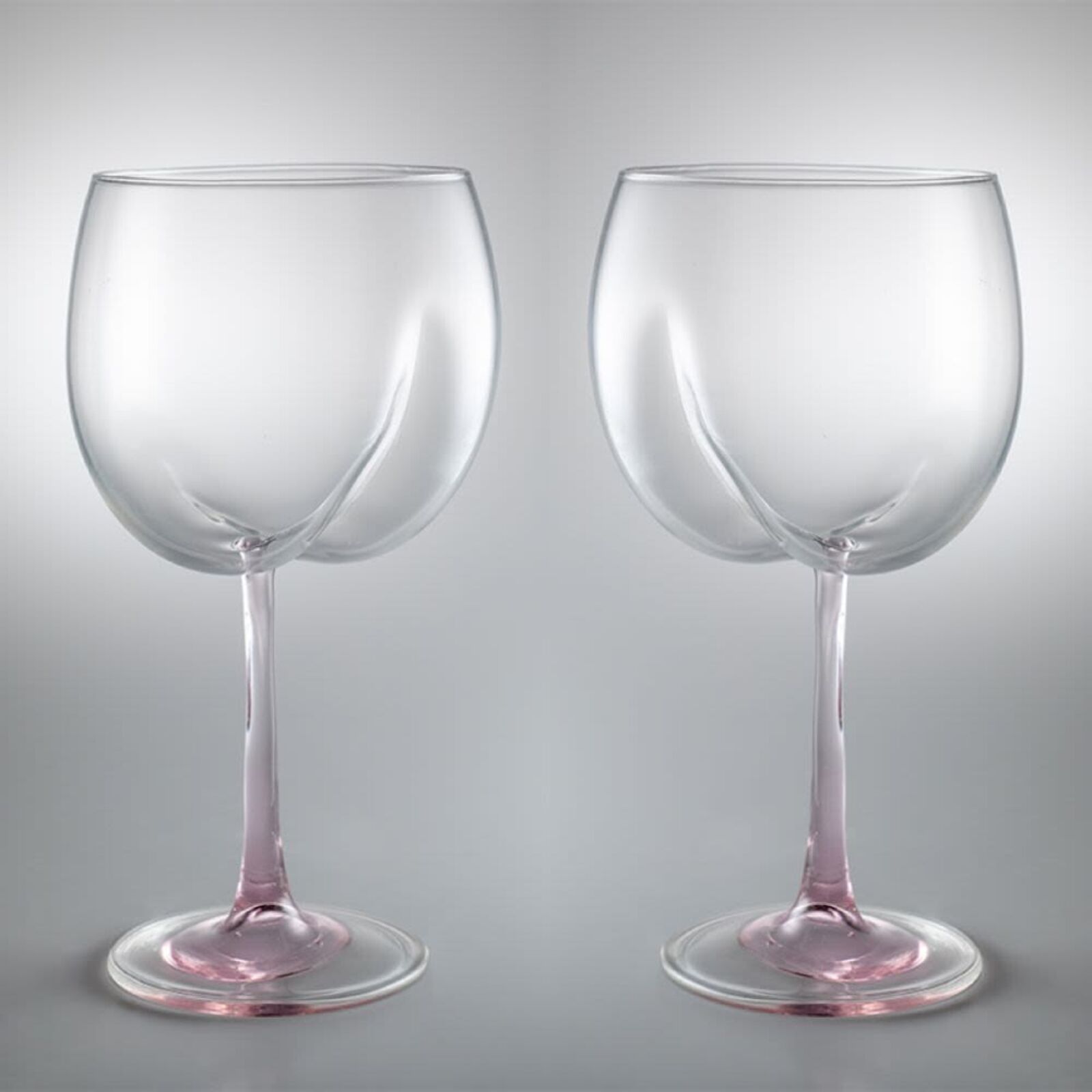 A pair of wine glasses sitting next to each other.