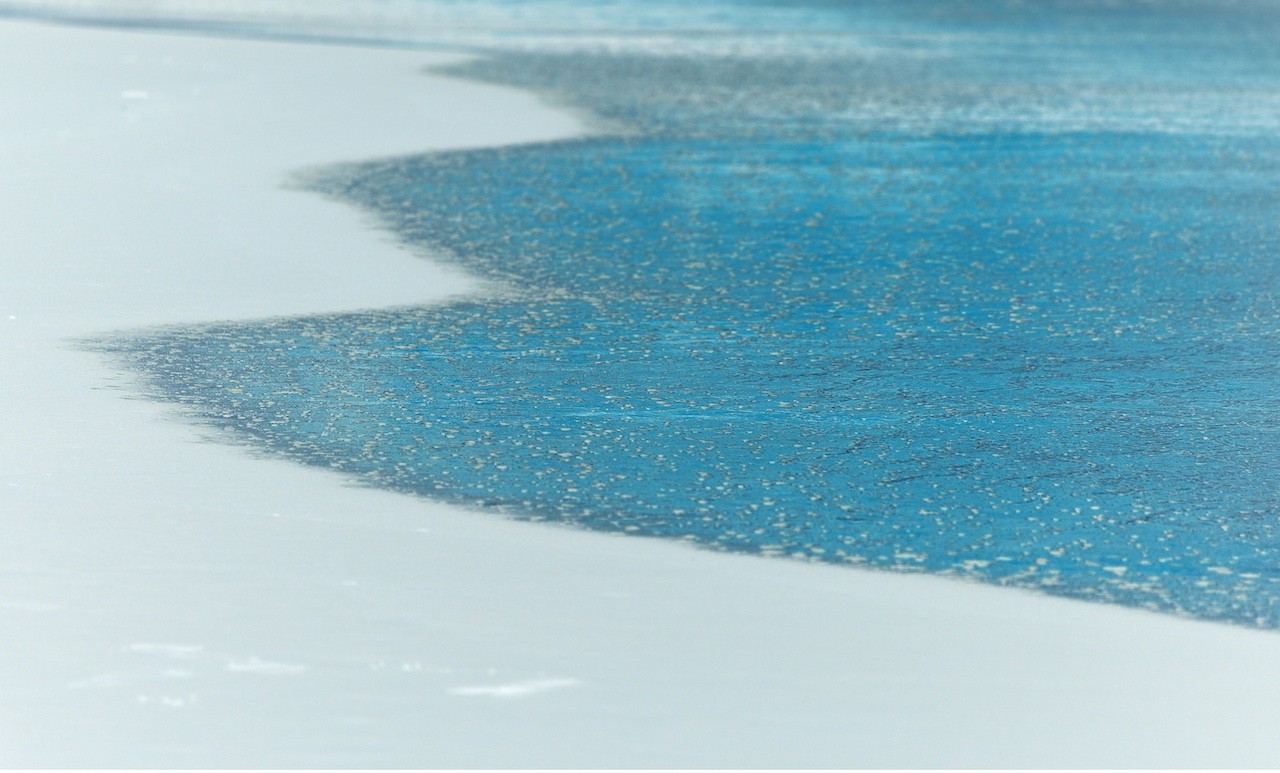 A minimalist abstract composition featuring a sharp diagonal division between white and textured blue.