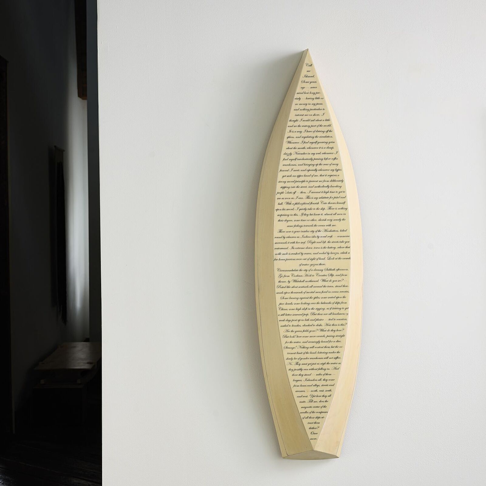 A minimalist wall art piece featuring a boat-shaped frame filled with dense text.