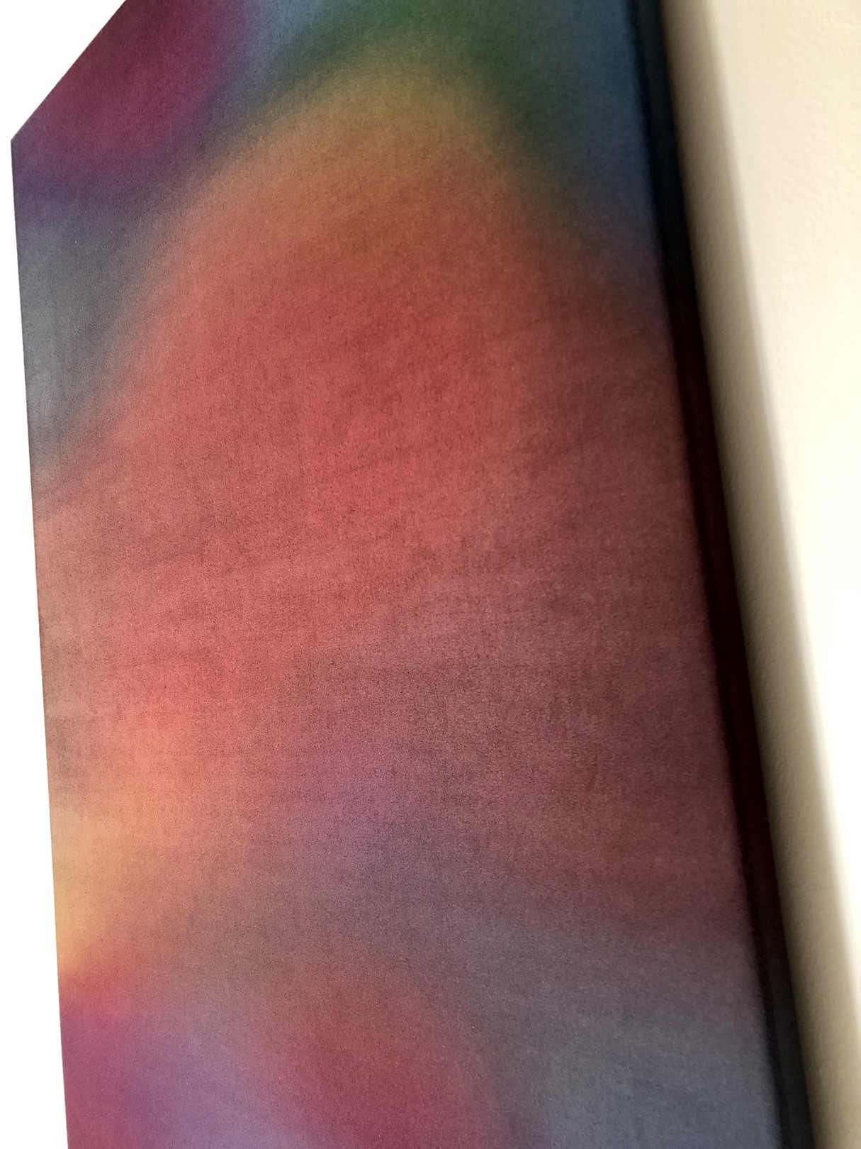 A vertical abstract composition featuring blurred, warm-toned shapes against a dark background.