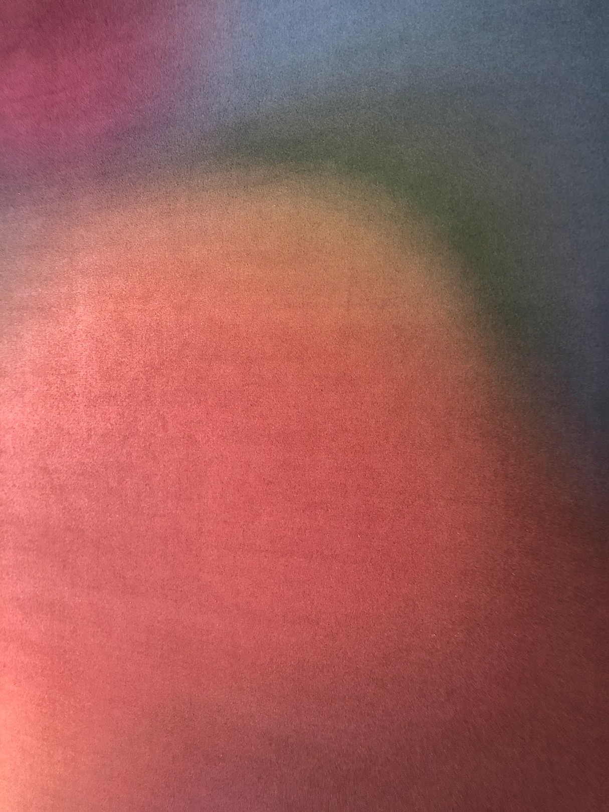 A vertical abstract composition featuring blurred, warm-toned shapes against a dark background.
