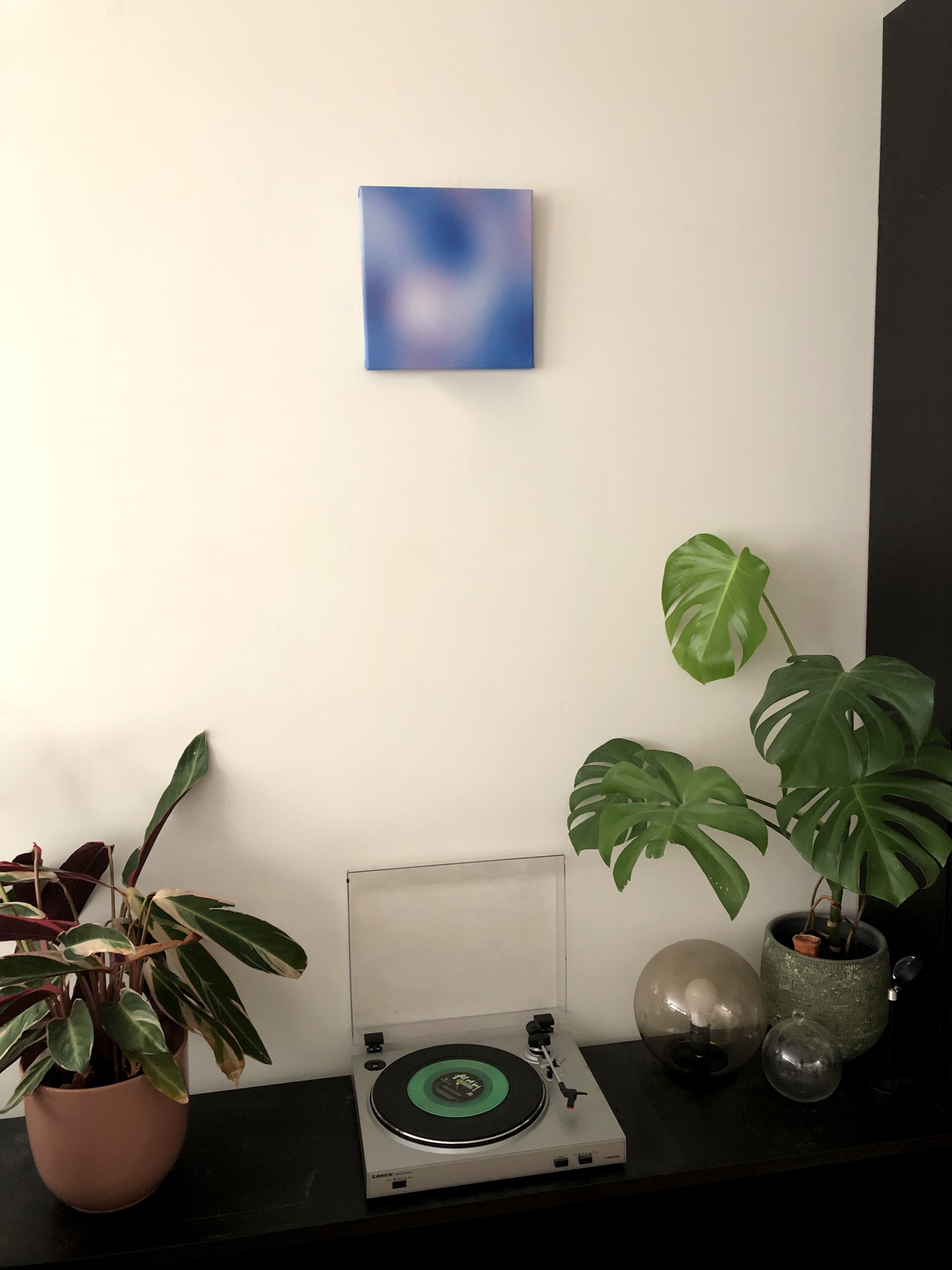 A blue and purple painting on a white wall.