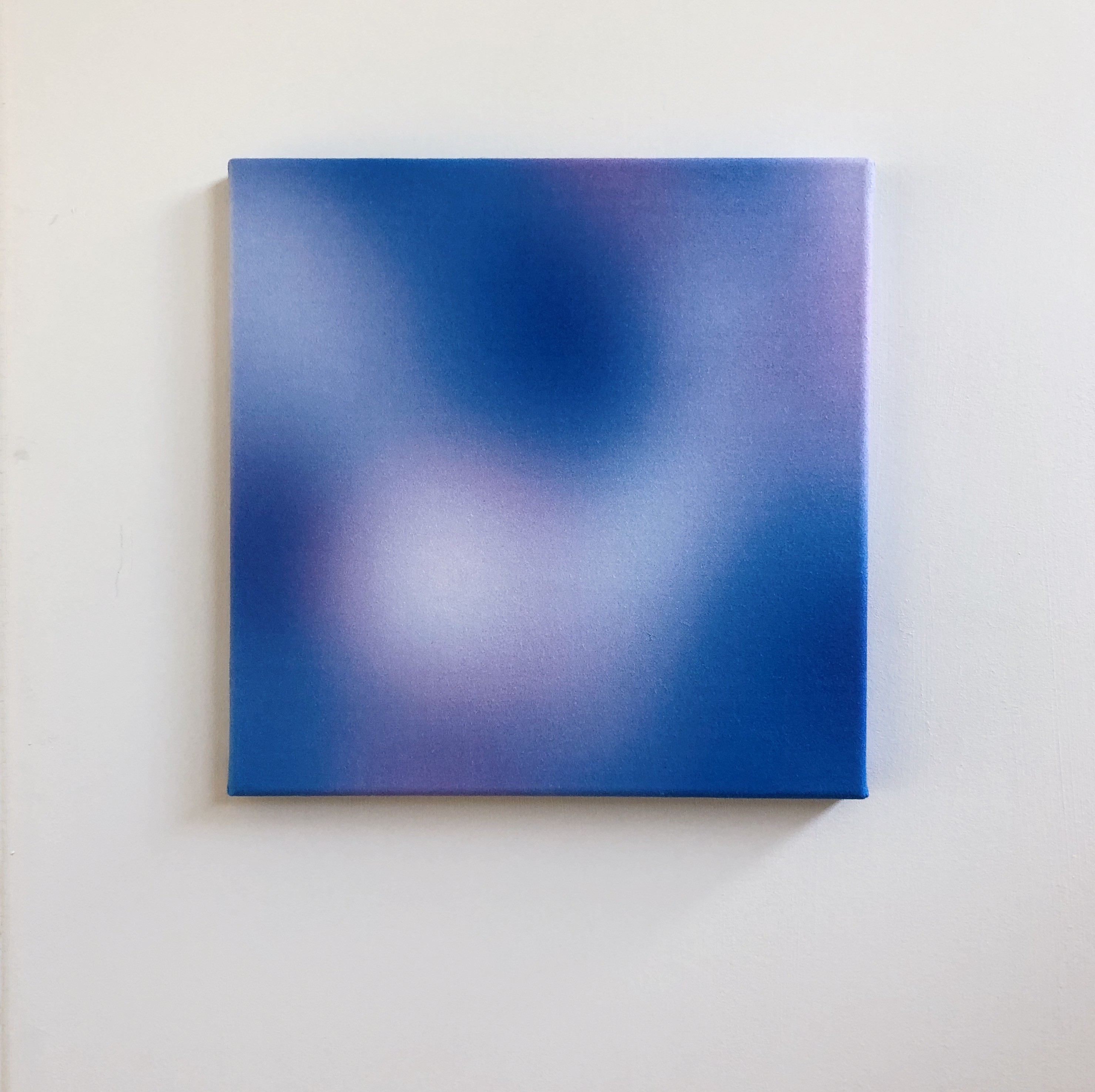 A blue and purple painting on a white wall.