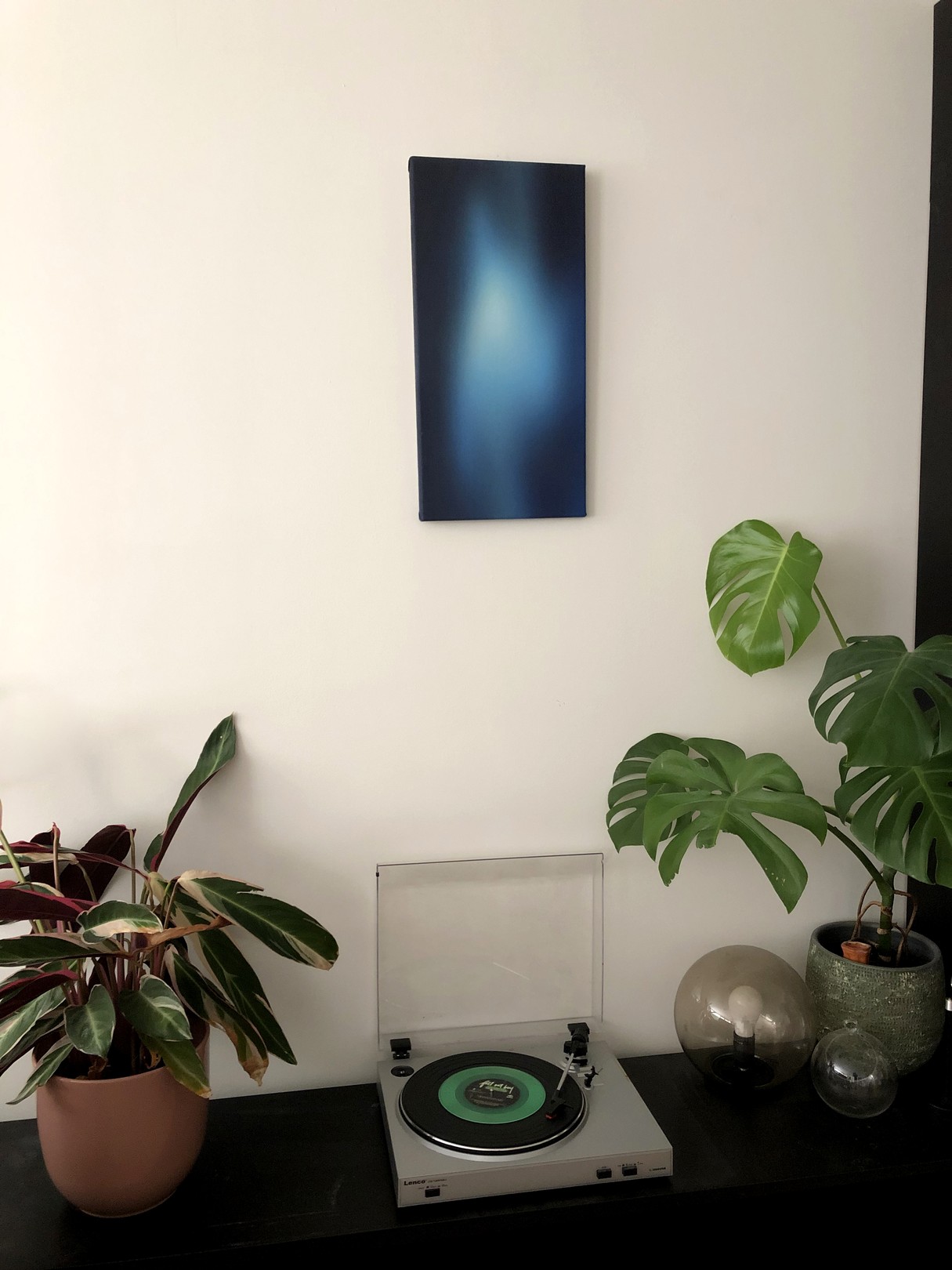 A minimalist abstract painting featuring a vertical gradient of blue tones.