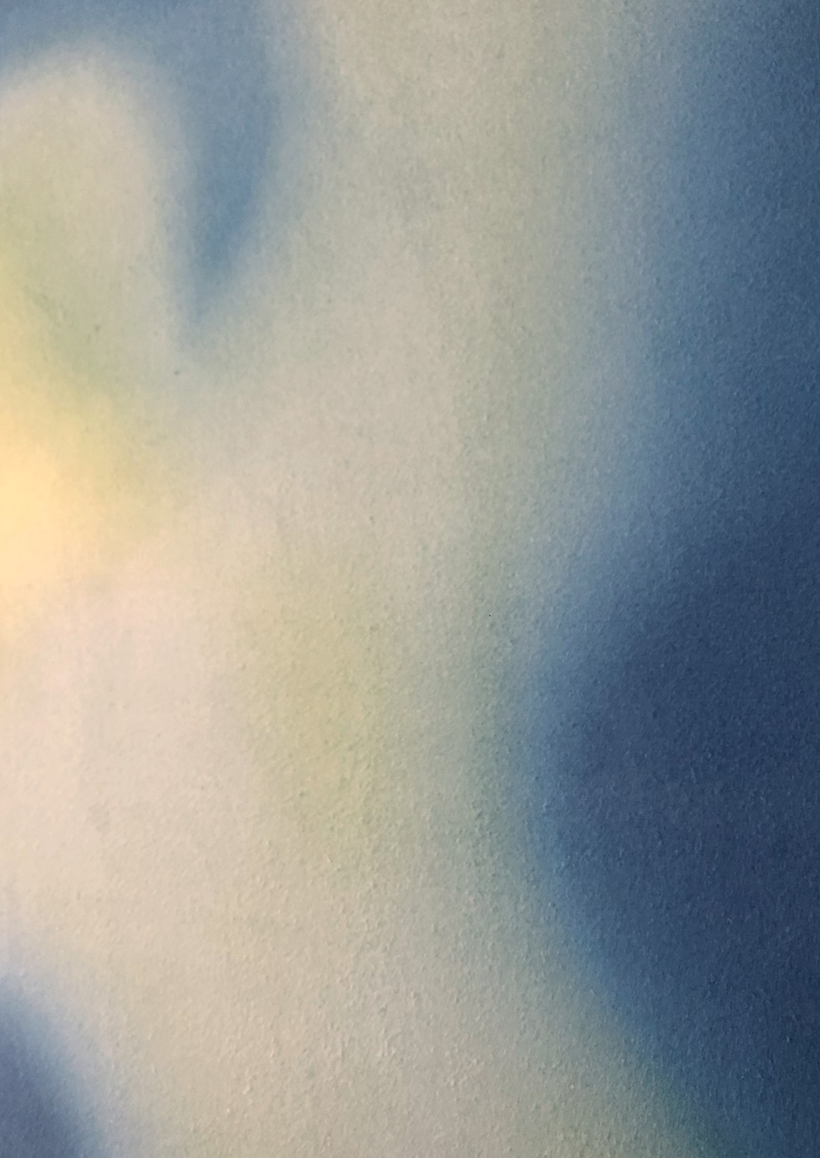 A minimalist abstract painting featuring soft blue and green gradients on a white wall.
