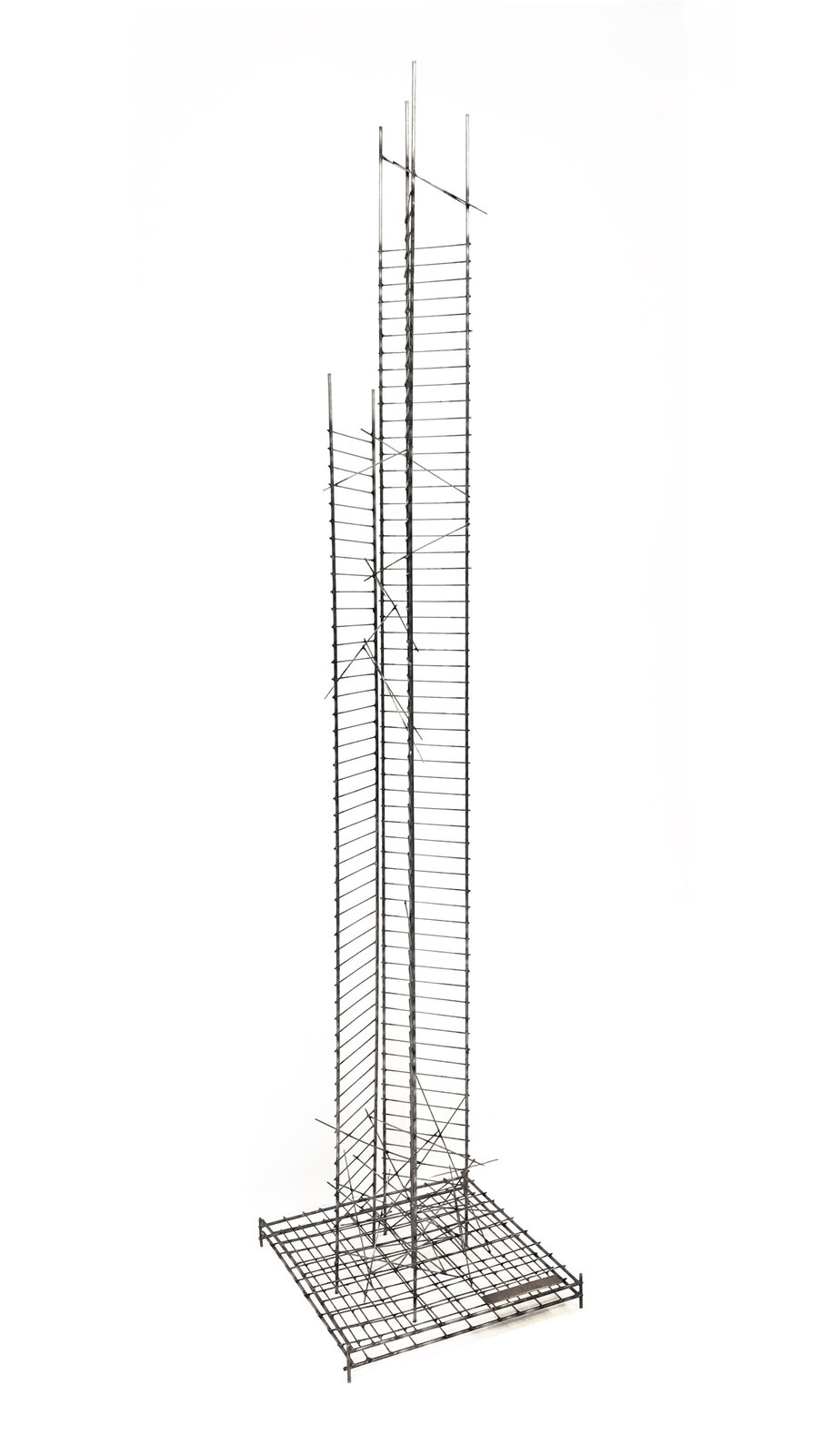 A tall, minimalist sculpture featuring a grid-like base and vertical wire structures against a stark white background.