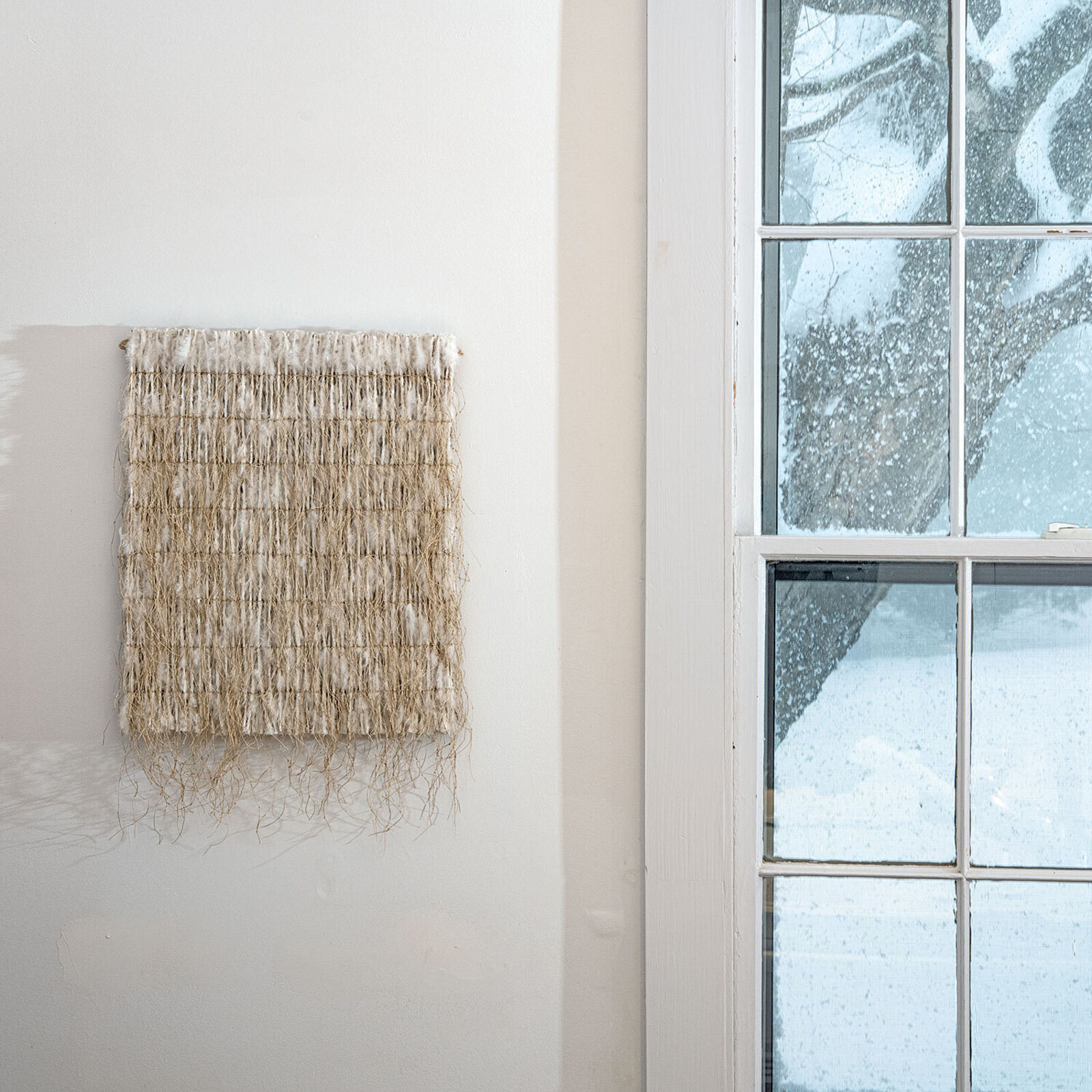 A piece of woven fabric on a white wall.