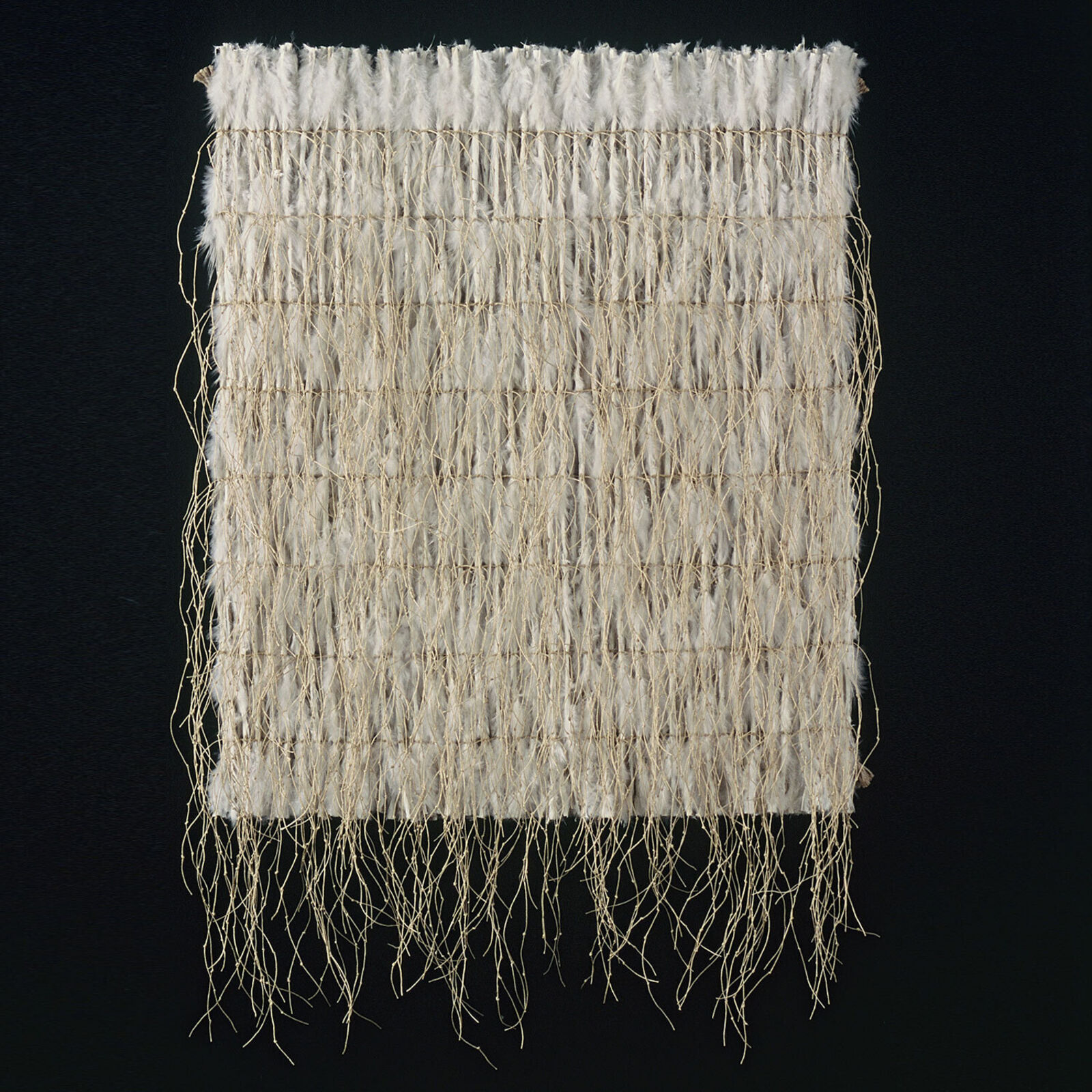 A piece of woven fabric on a white wall.