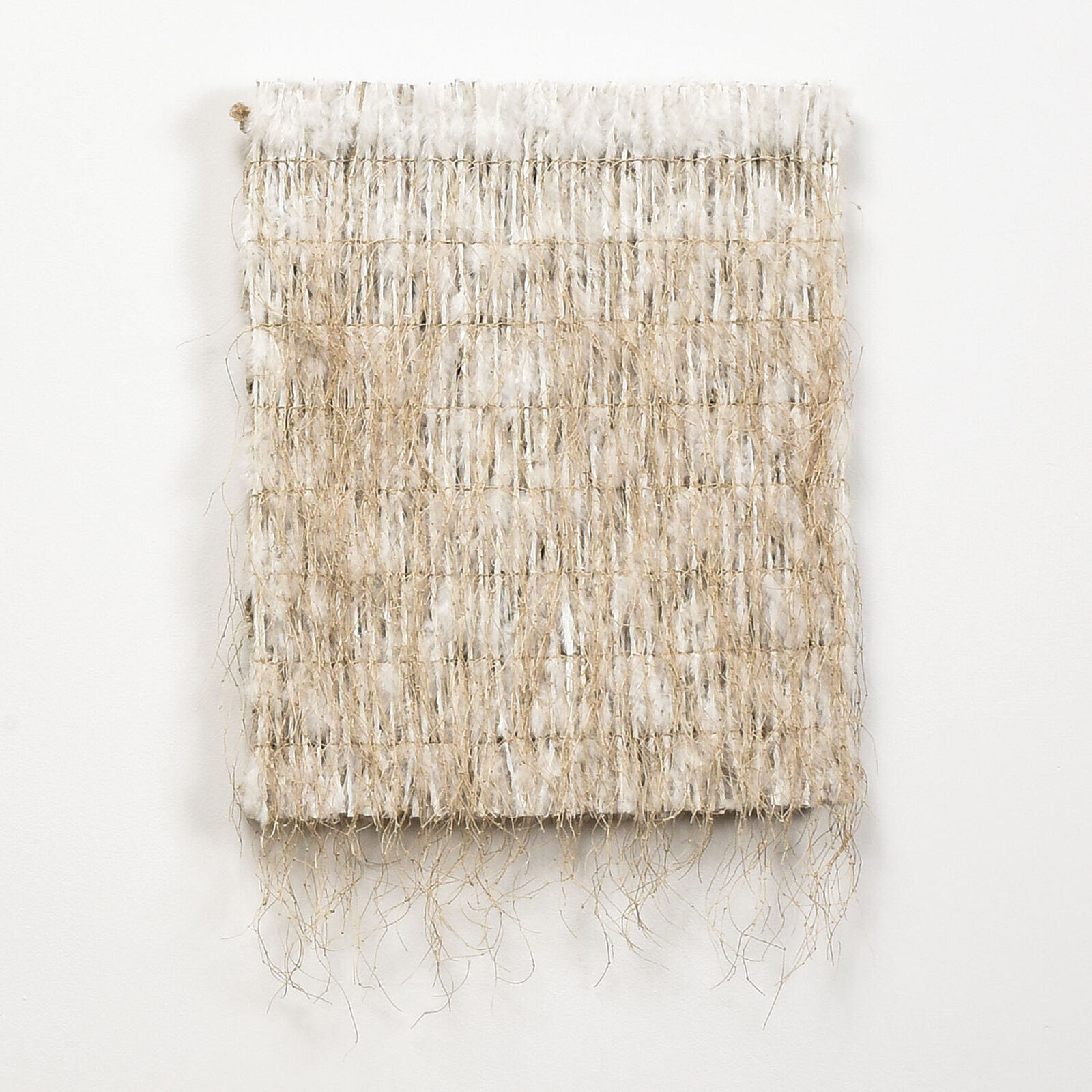 A piece of woven fabric on a white wall.