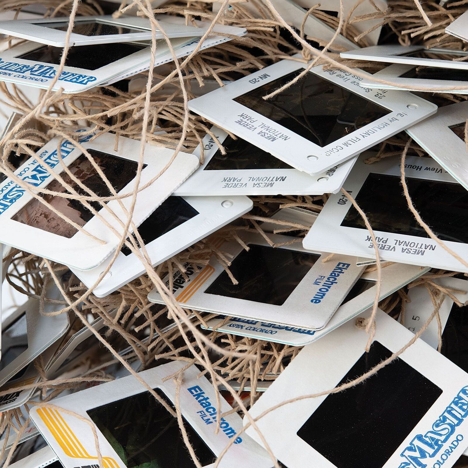A chaotic pile of vintage slide frames tangled with twine.