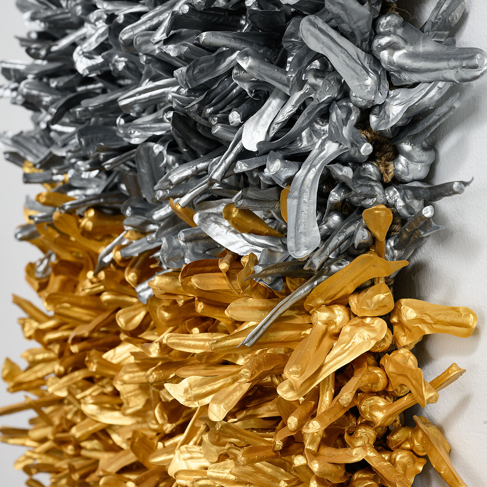 A textured square artwork composed of two distinct metallic sections, one silver and one gold.