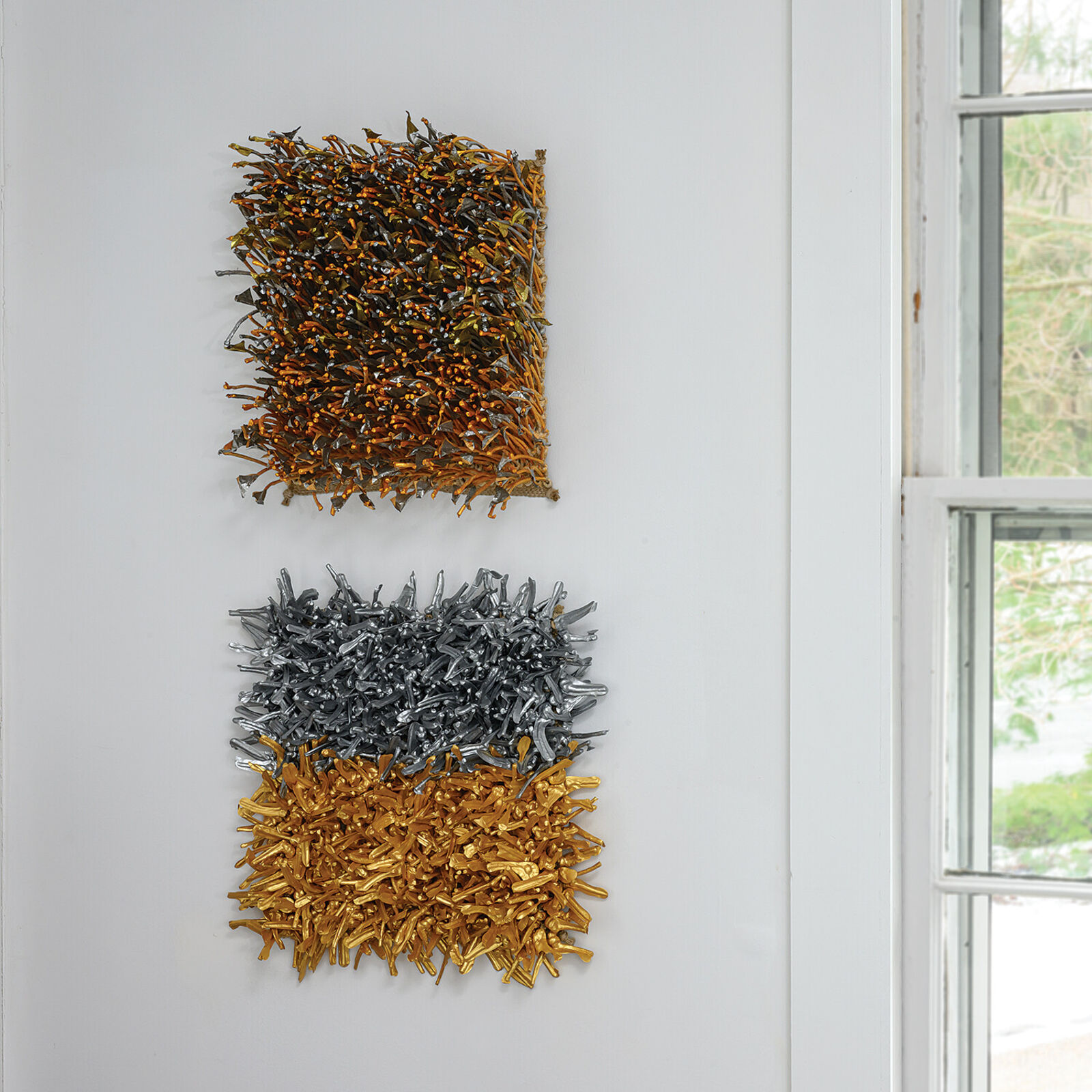 A textured square artwork composed of two distinct metallic sections, one silver and one gold.