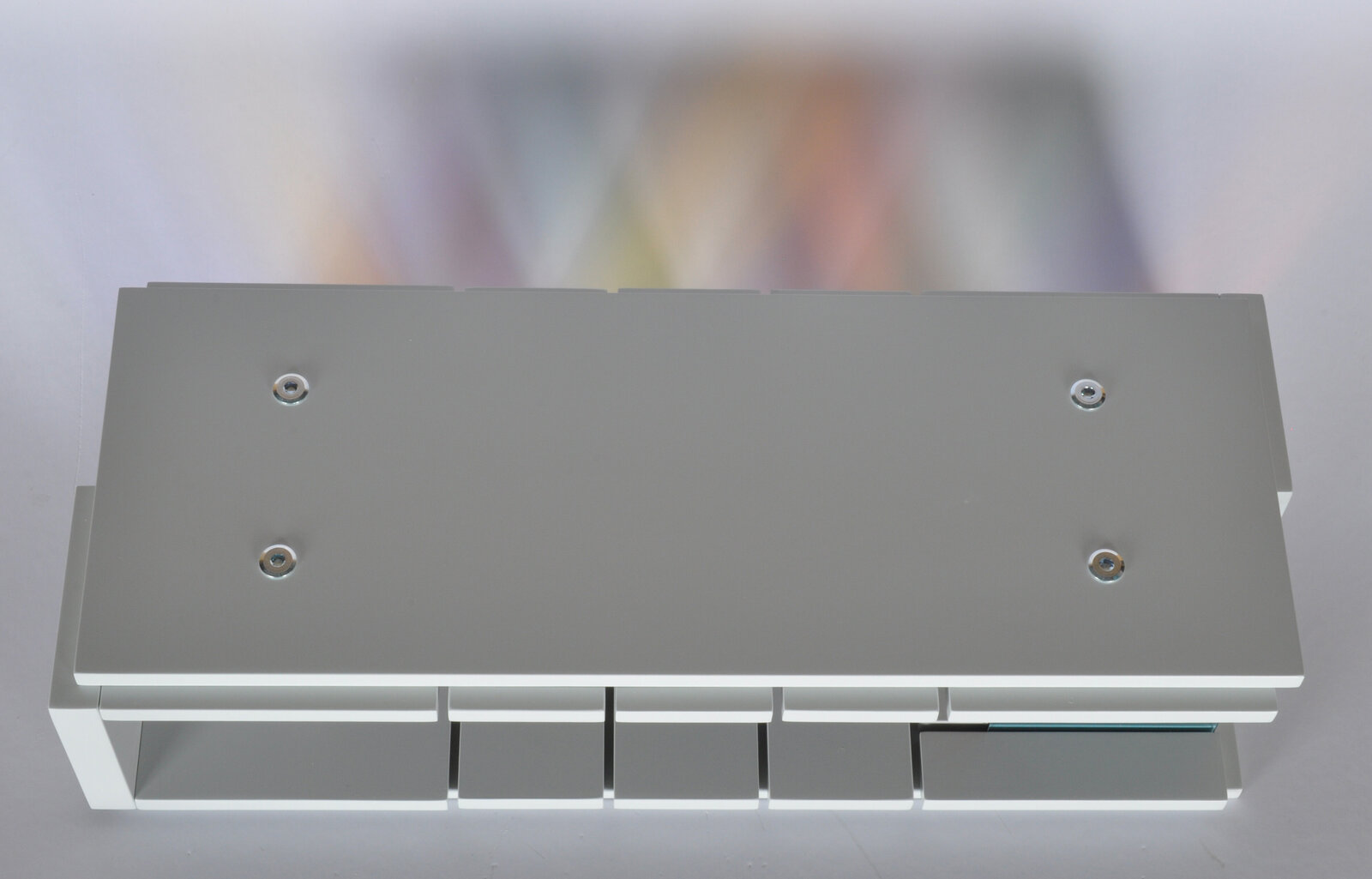 A sleek white console table featuring a row of colorful translucent panels.