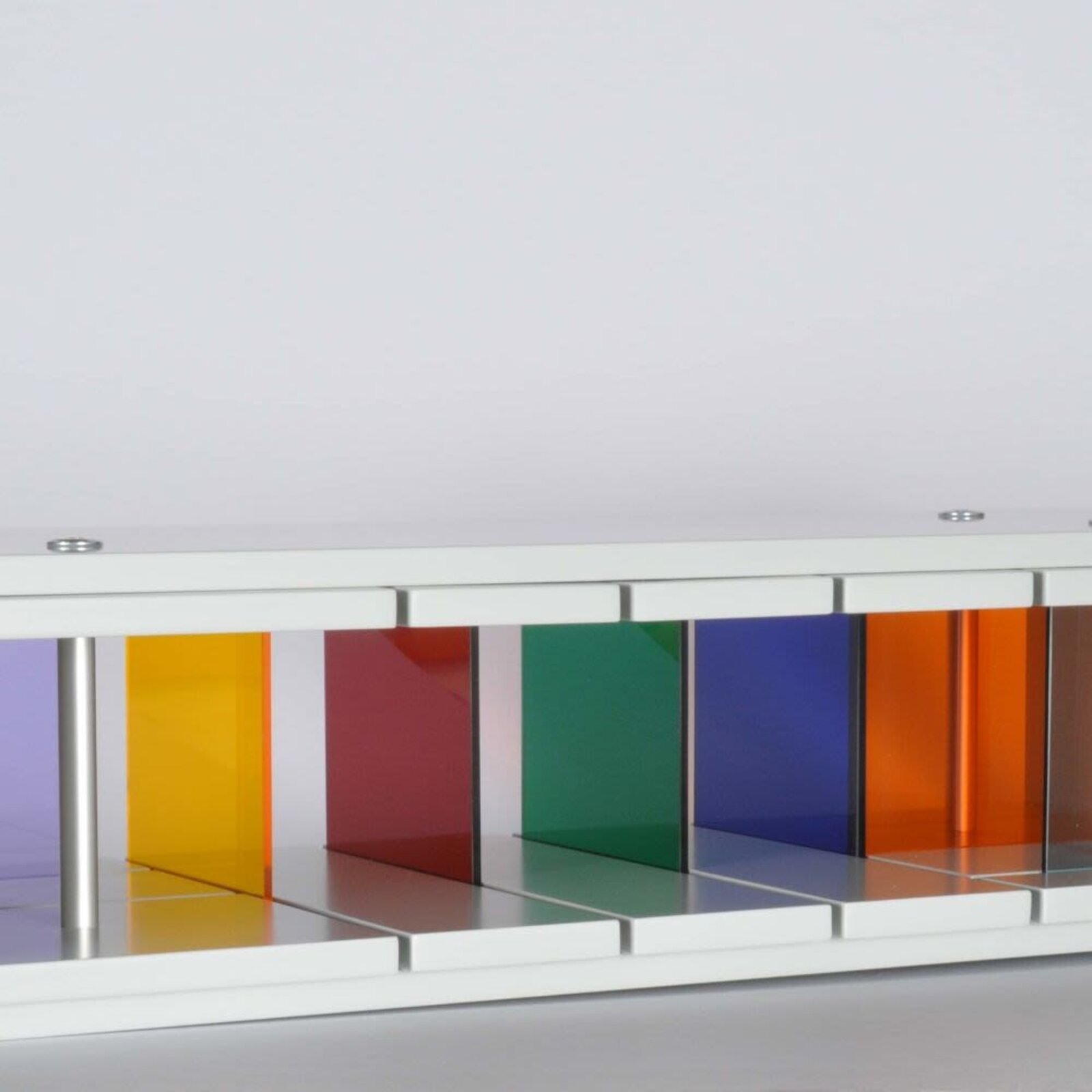 A sleek white console table featuring a row of colorful translucent panels.