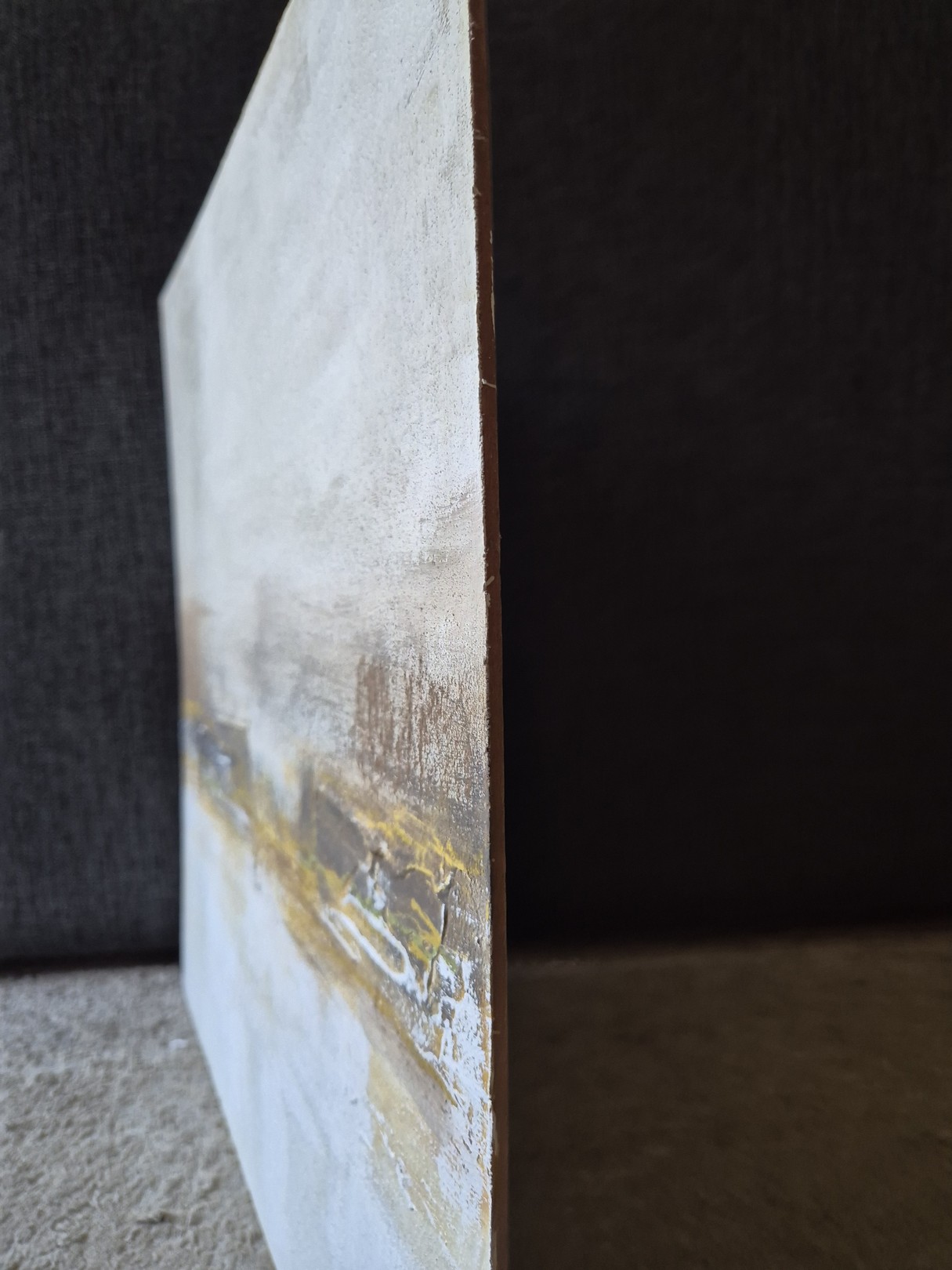 An abstract textured surface with layered earthy tones and white highlights.