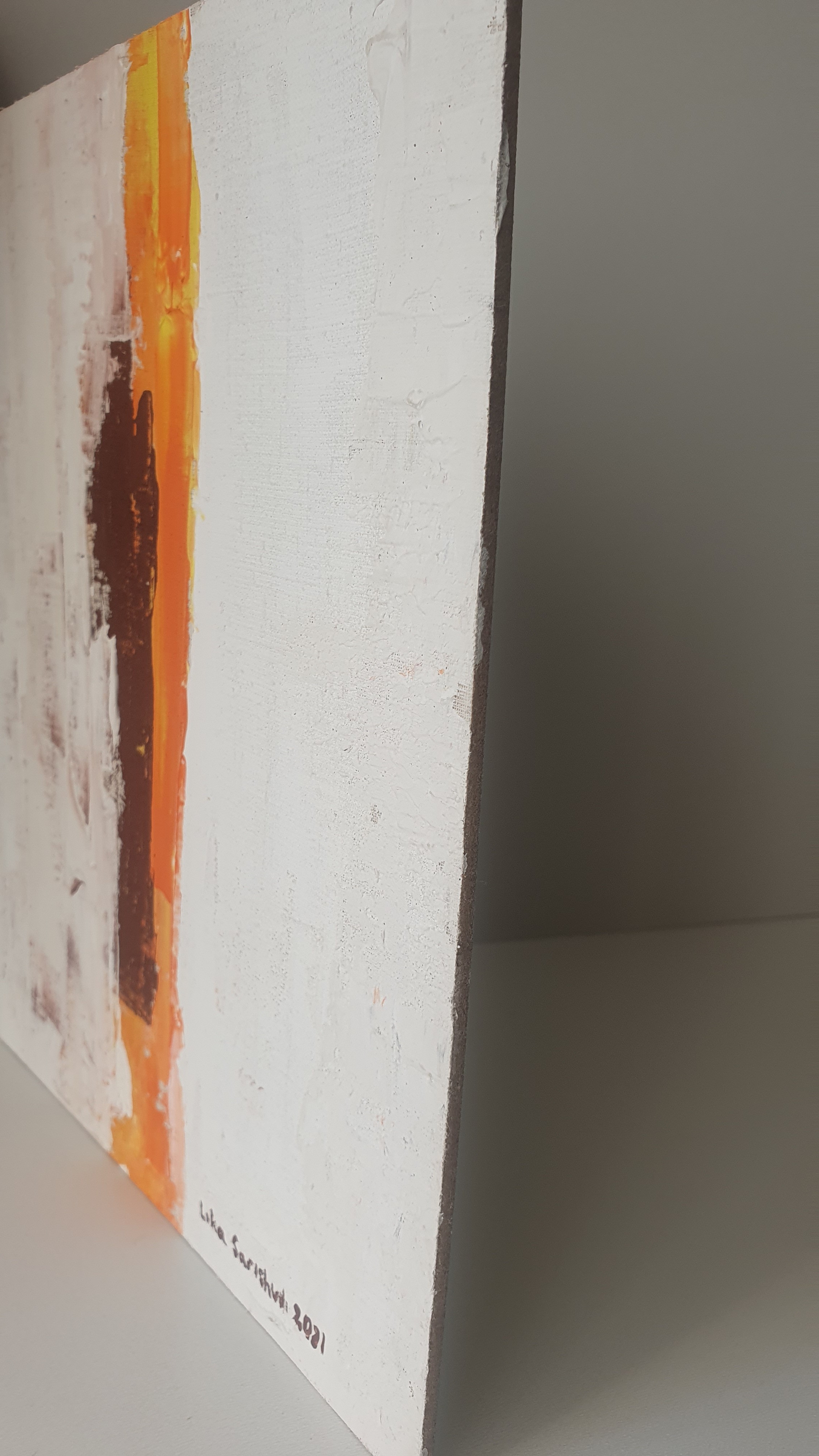 A close up of a painting on a white wall.