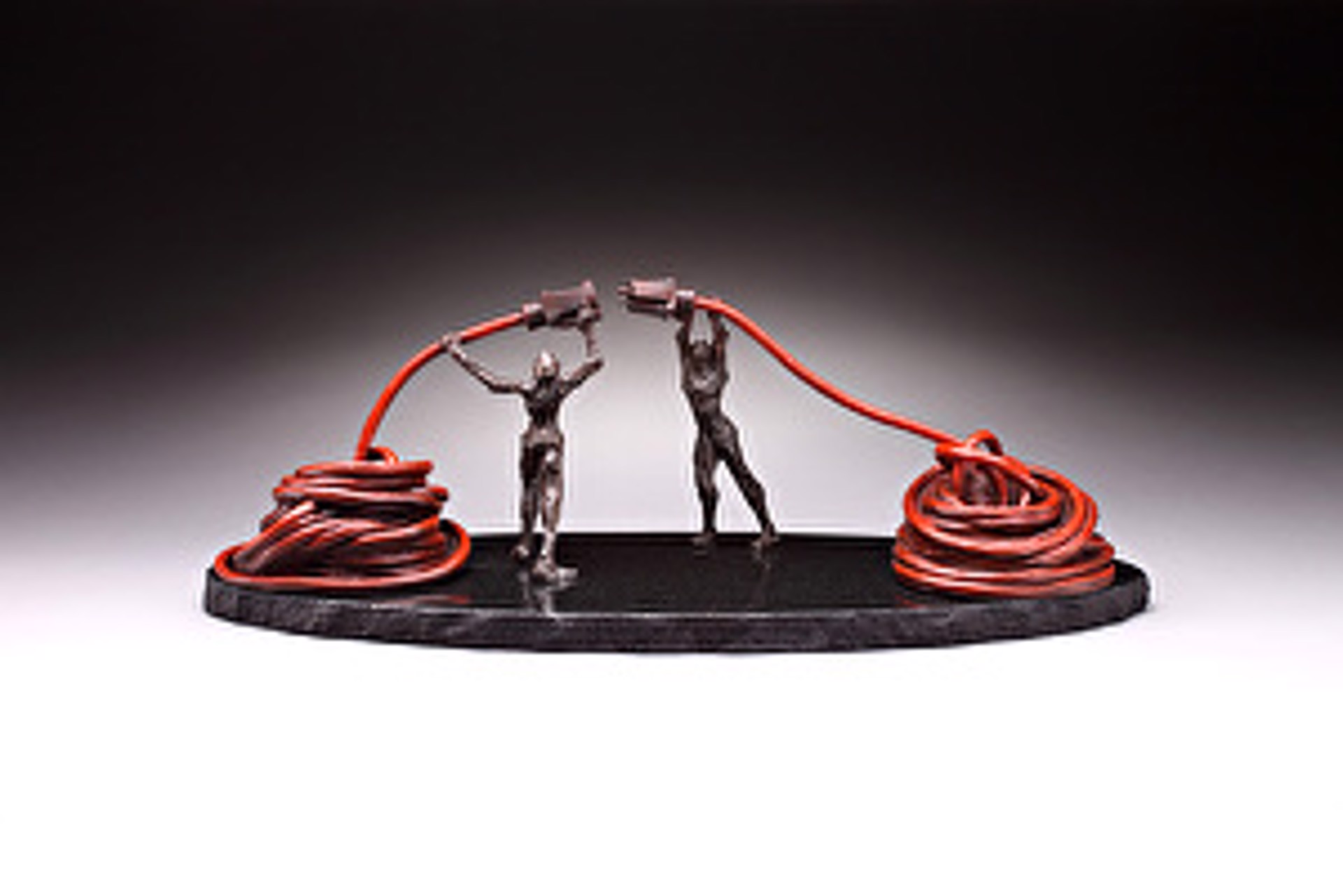 A couple of people that are standing on a black base.