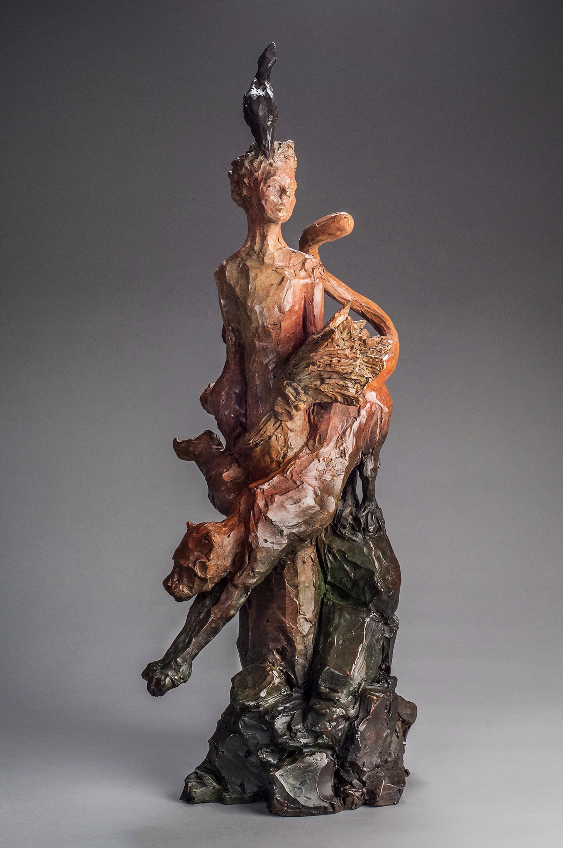 A sculpture of a woman sitting on top of a rock.