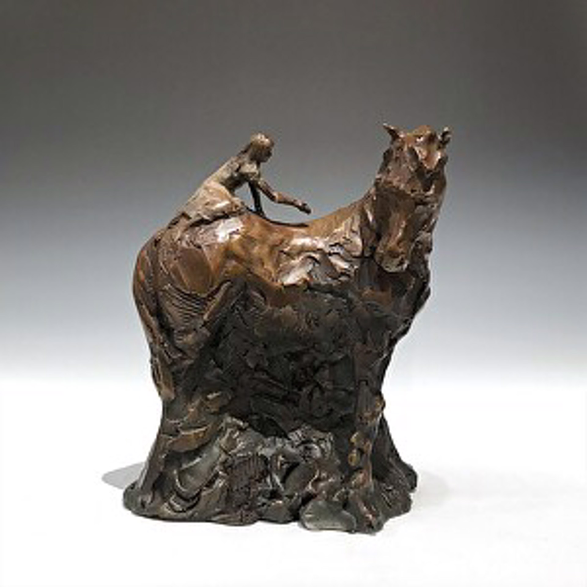 A bronze sculpture of a woman riding a horse.