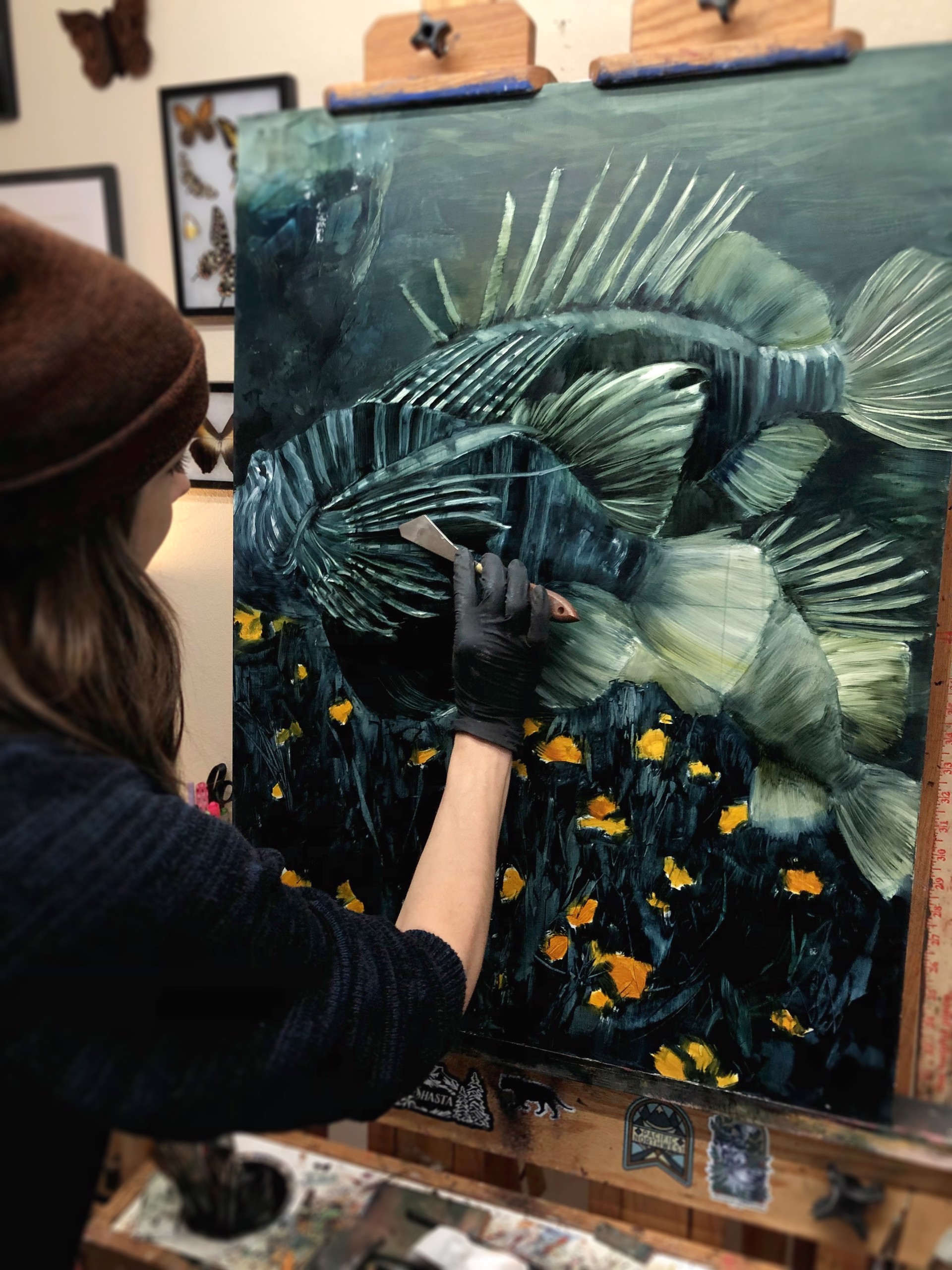 A painting of a lionfish in a field of yellow flowers.