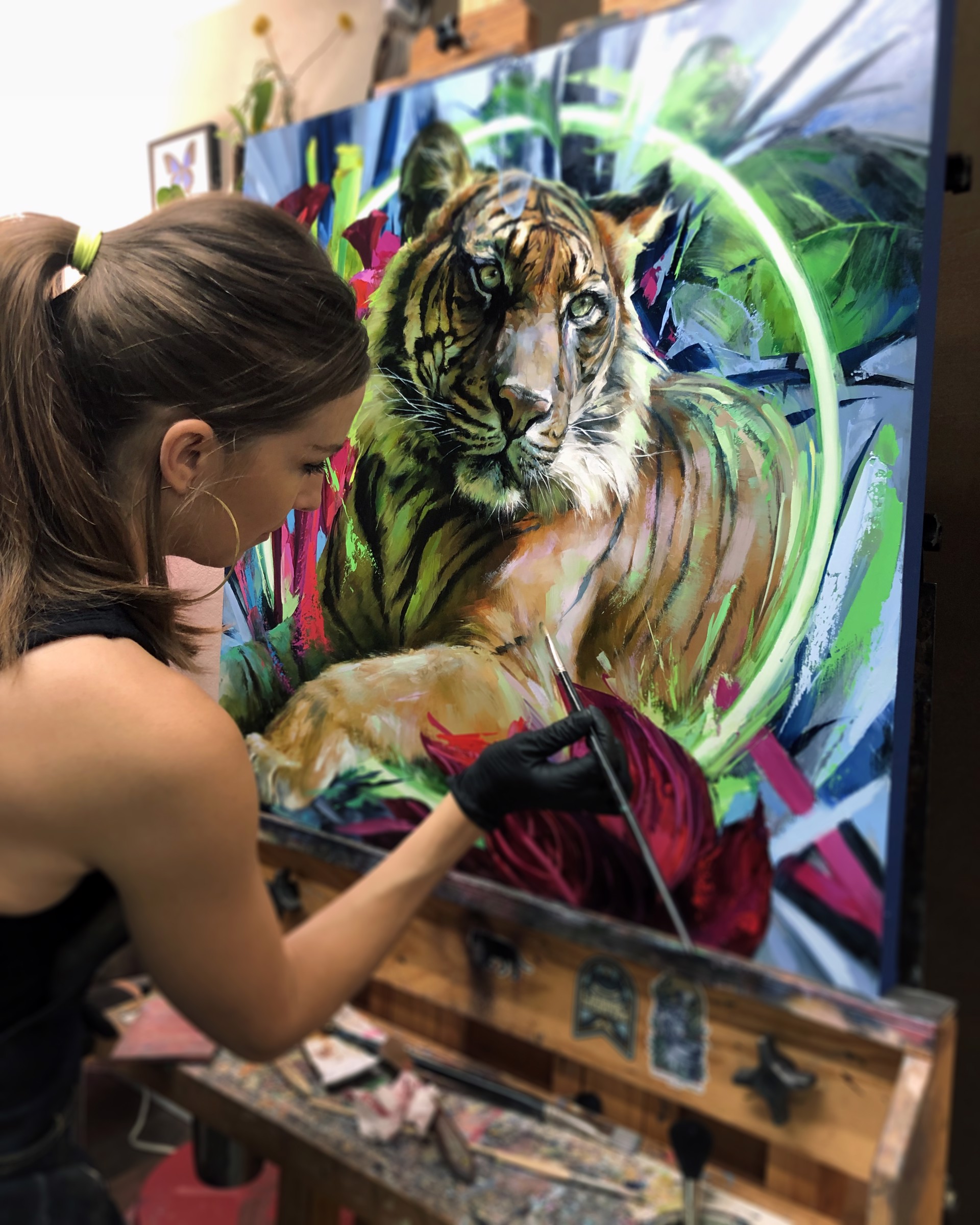 A painting of a tiger laying down in a field of flowers.