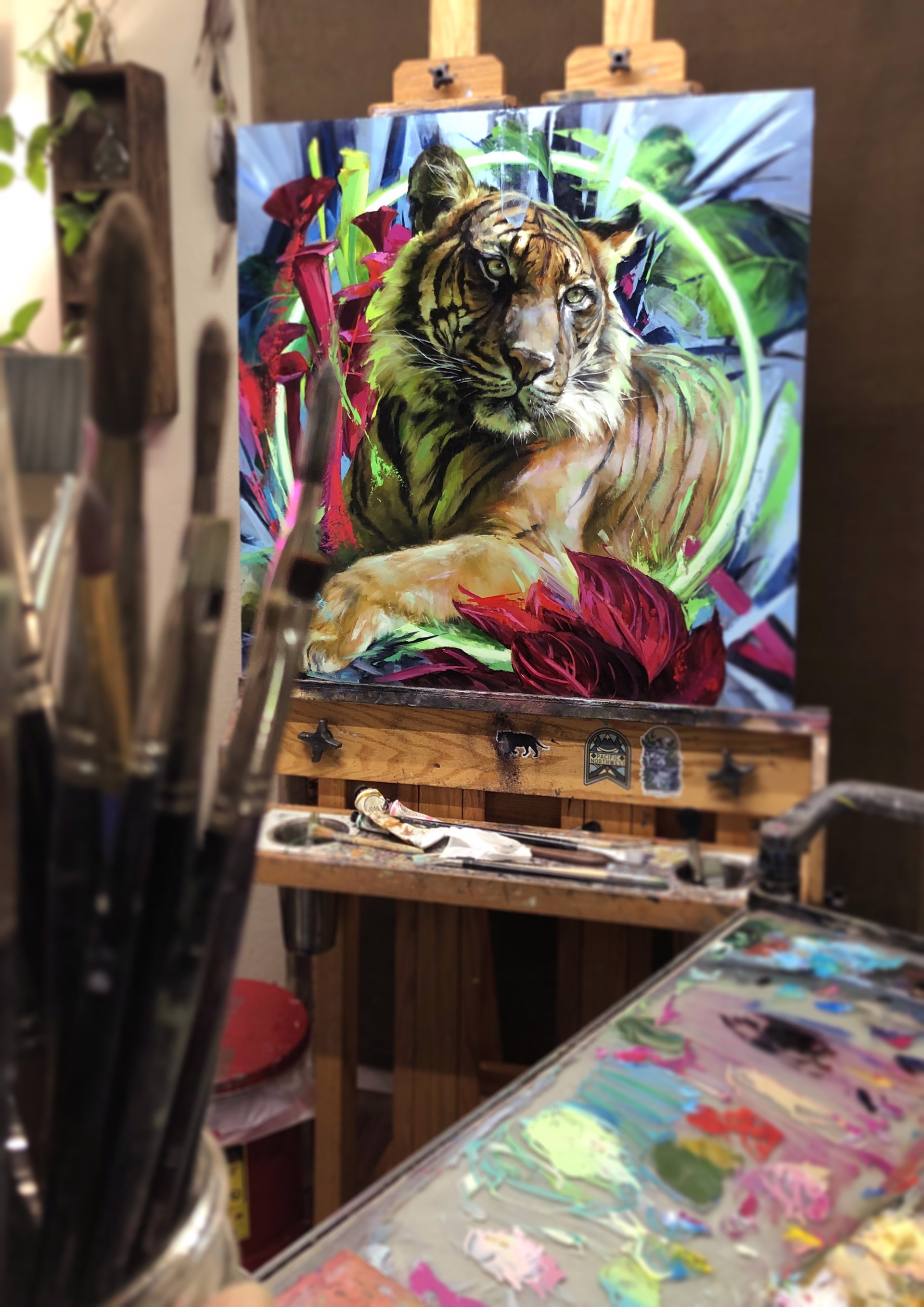 A painting of a tiger laying down in a field of flowers.