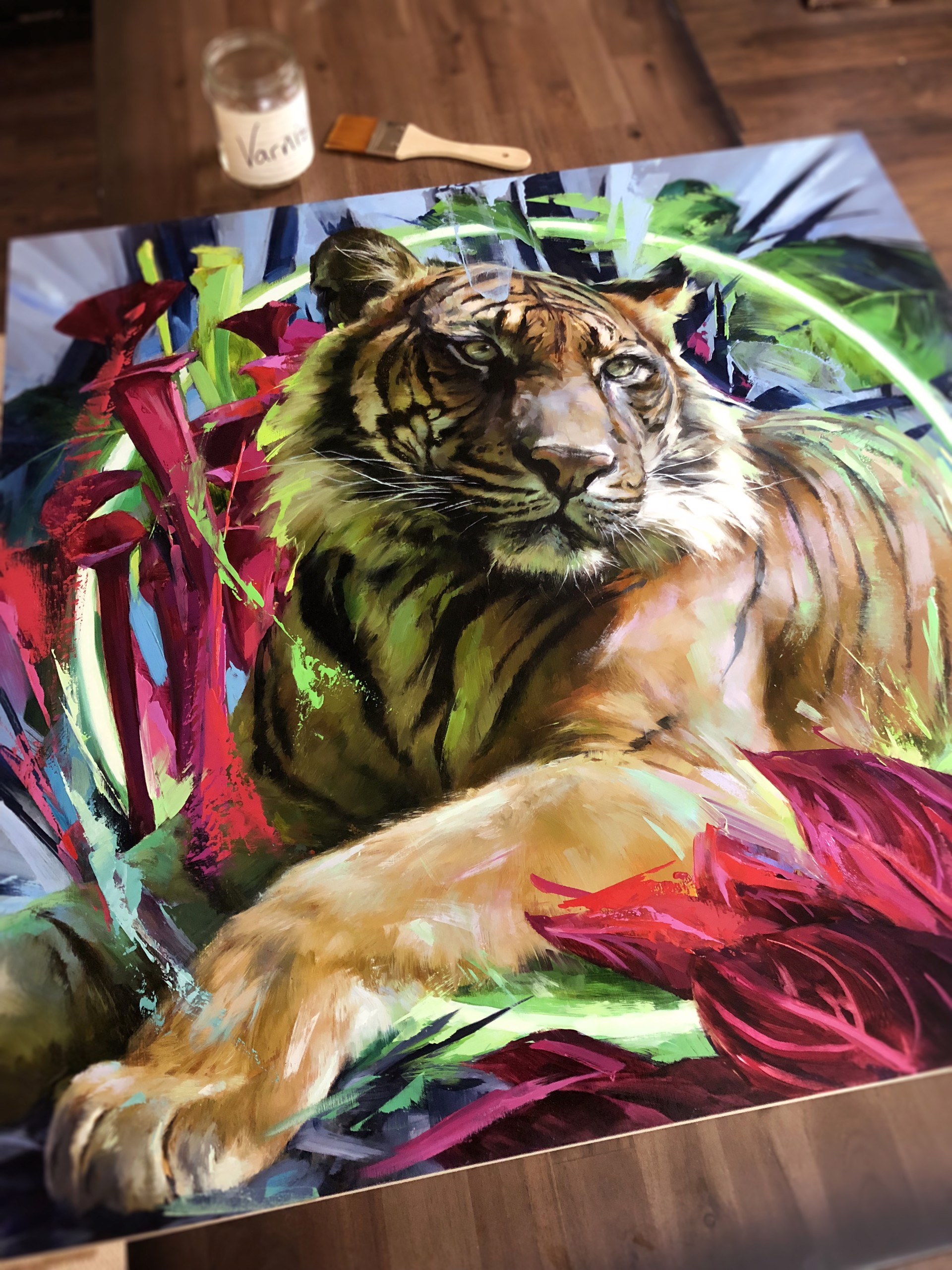 A painting of a tiger laying down in a field of flowers.