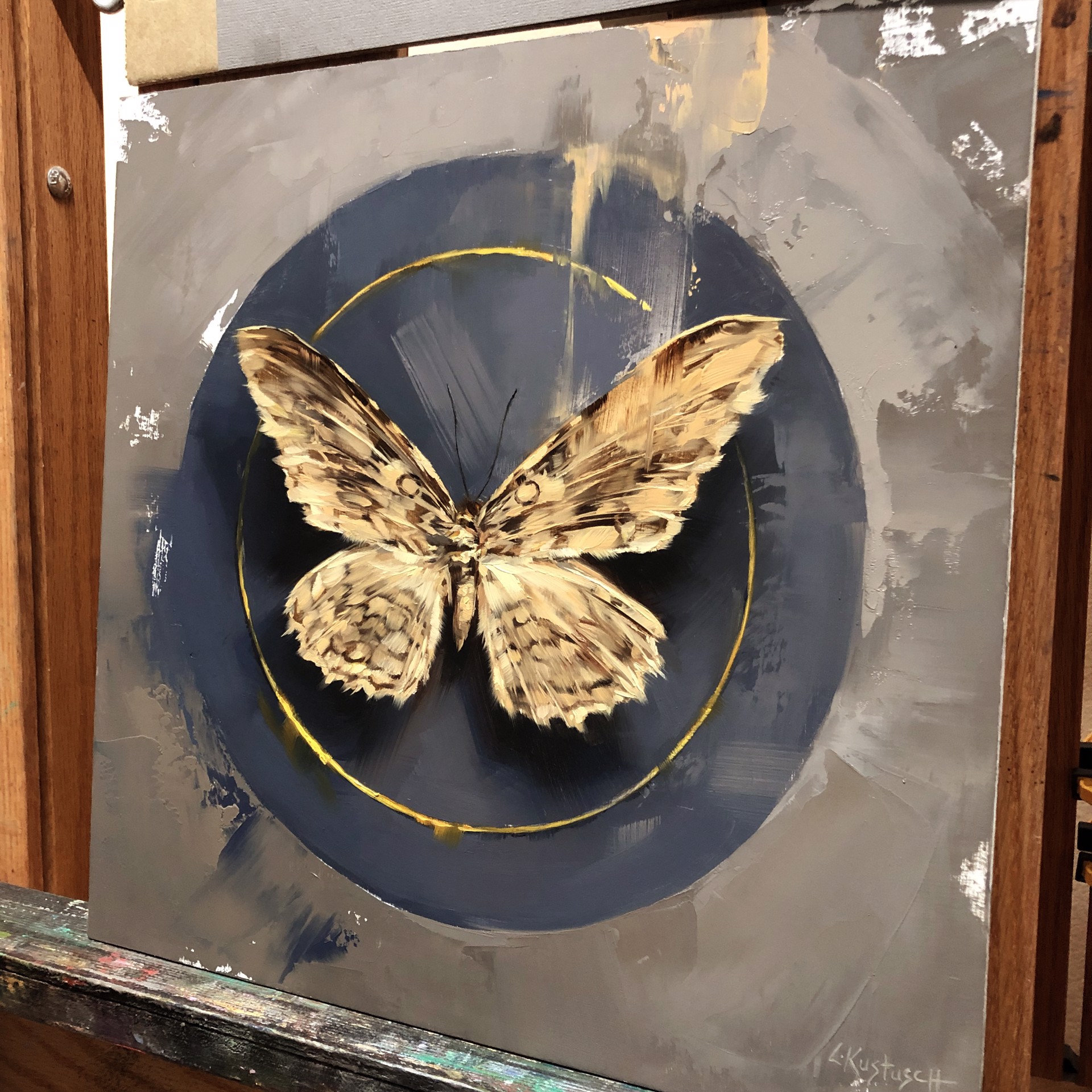 A painting of a butterfly on a blue circle.