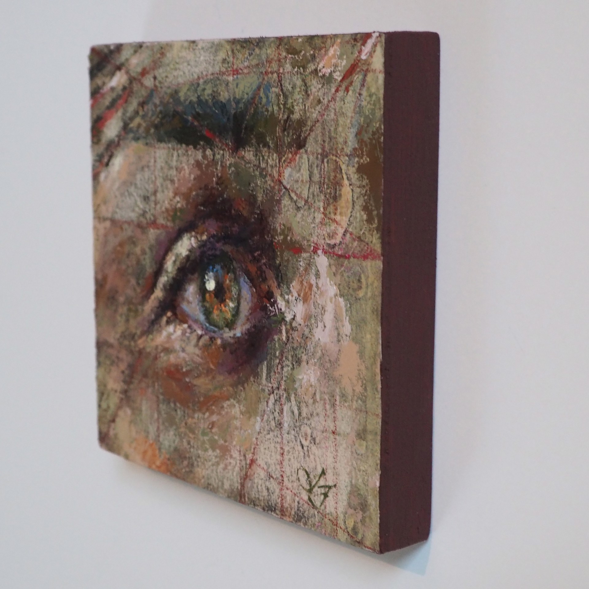 A painting of a woman's eye on a piece of paper.