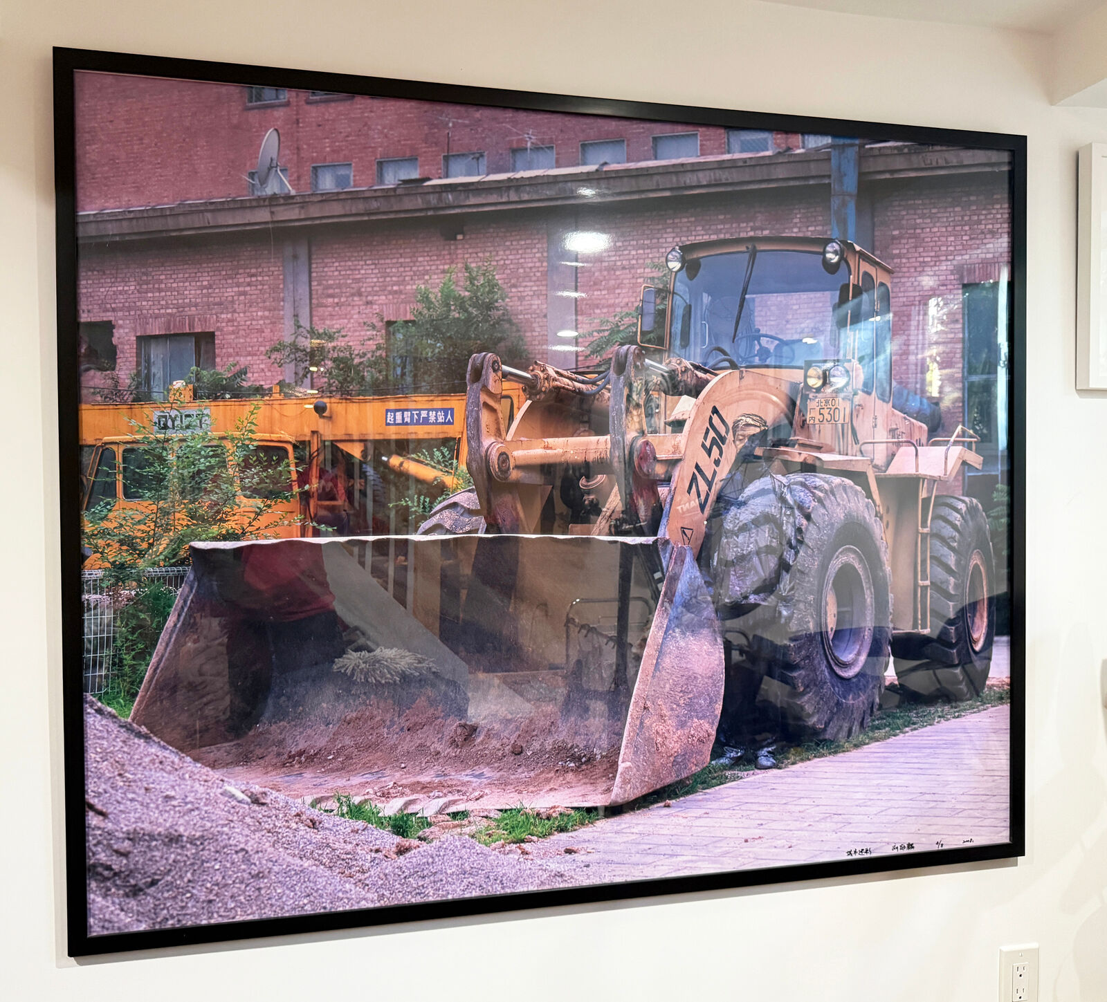 A picture of a bulldozer on a wall in a room.