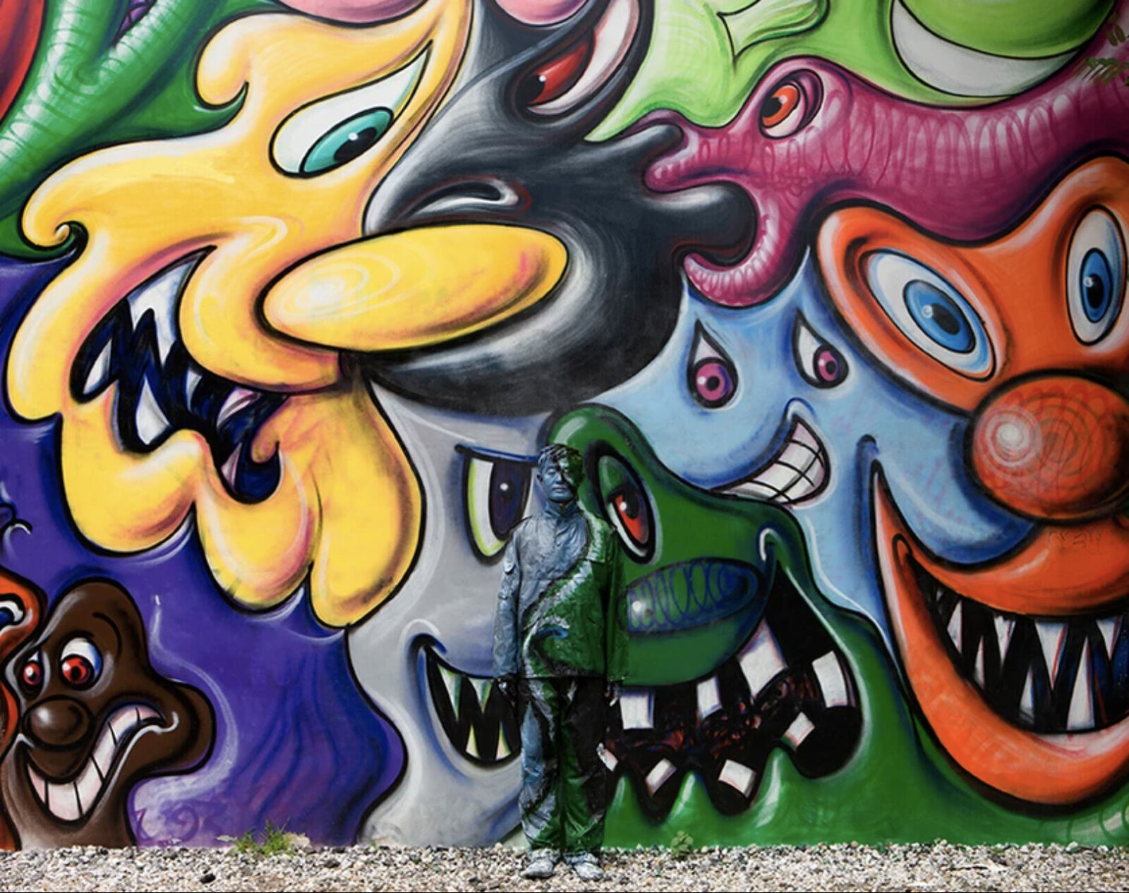 A painting of a man standing in front of a wall covered in graffiti.