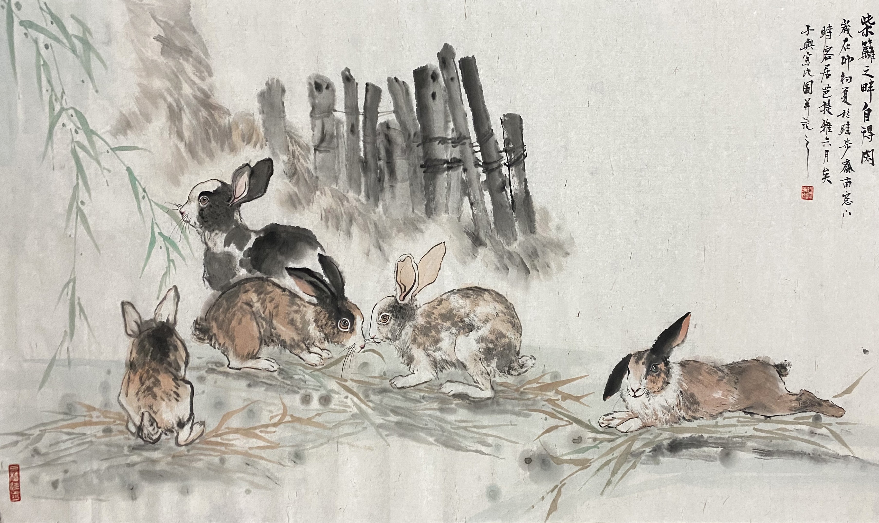 A traditional ink painting of a group of rabbits resting near a bamboo fence.