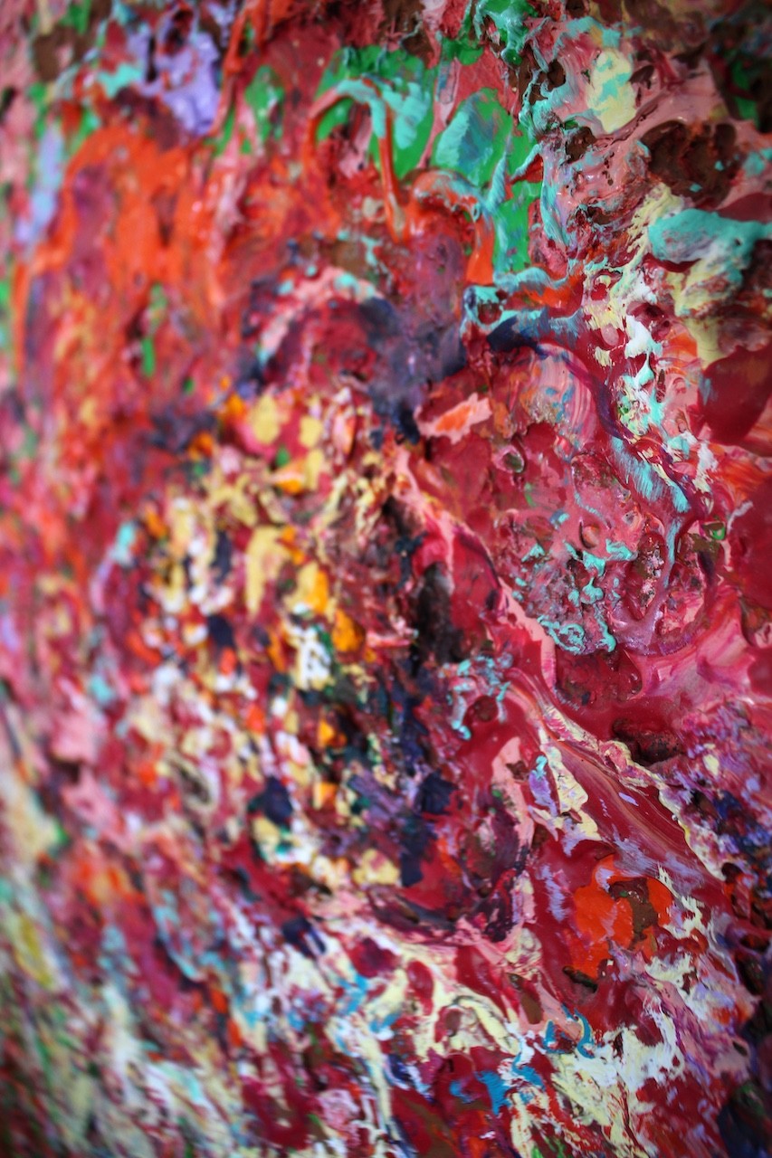 A vibrant abstract floral explosion bursting with reds, pinks, and greens against a dark void.