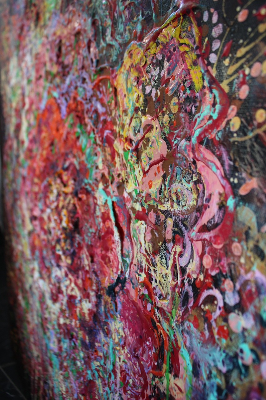 A vibrant abstract floral explosion bursting with reds, pinks, and greens against a dark void.