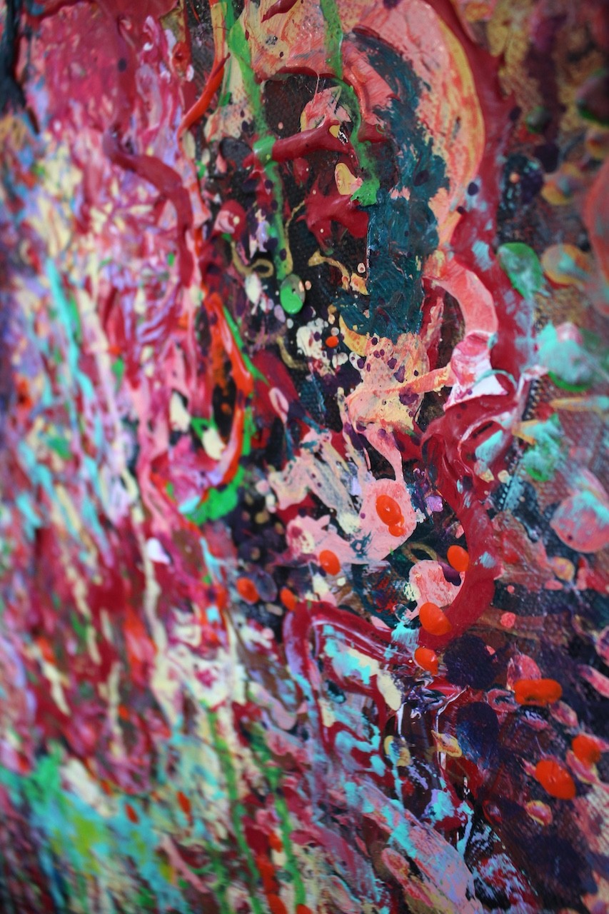 A vibrant abstract floral explosion bursting with reds, pinks, and greens against a dark void.